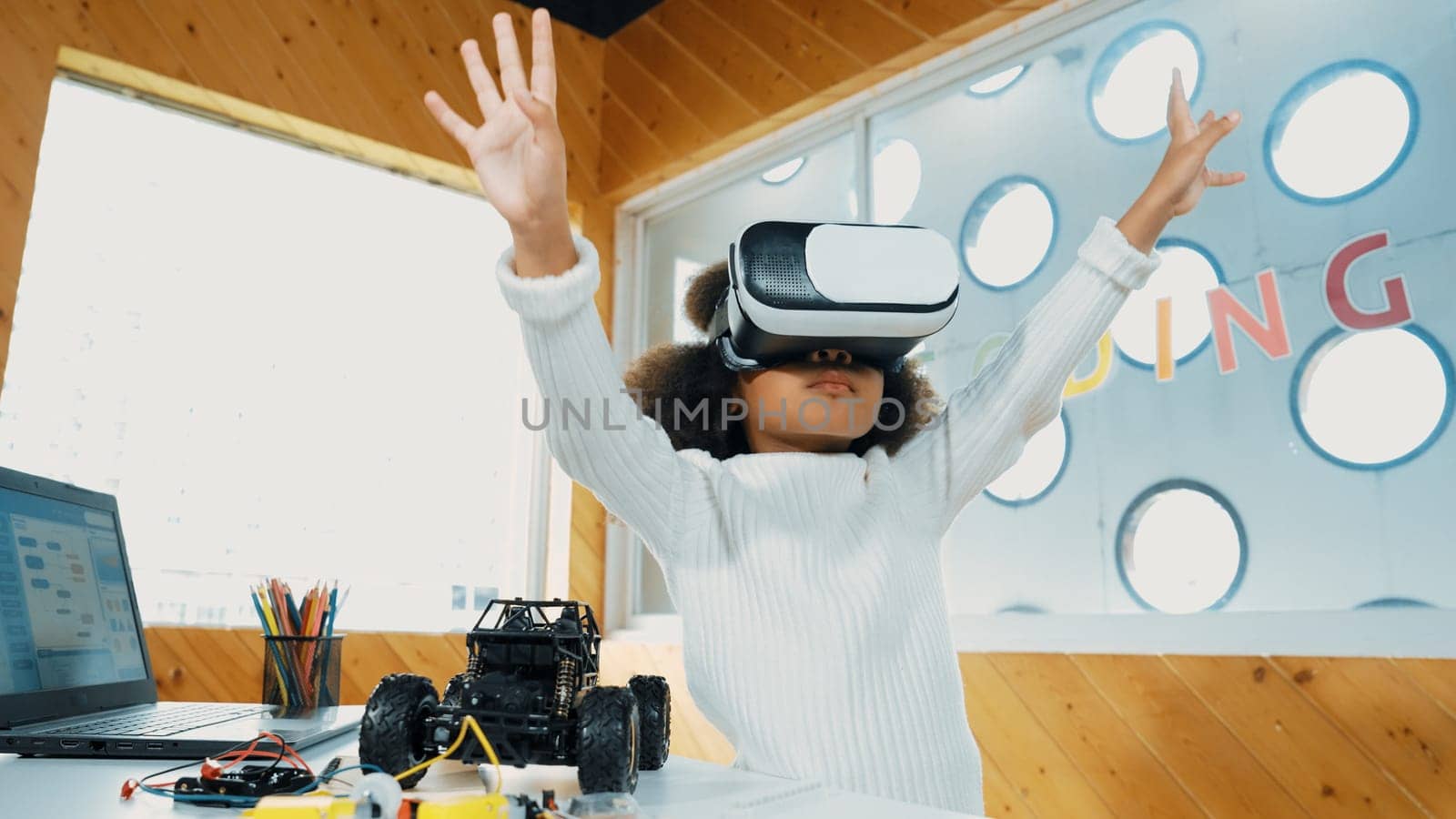 Creative girl wearing VR headset to learning in metaverse. Funny kid enjoy to wearing AI headset and enter to virtual world program in STEM technology class. Innovation. Future lifestyle. Erudition.