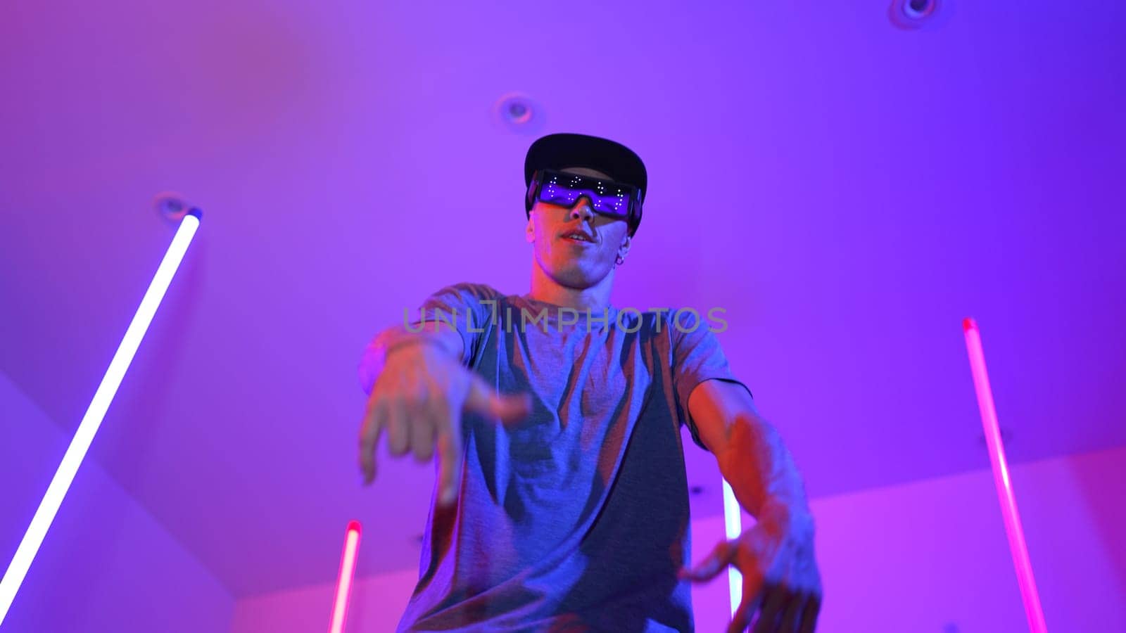 Low angle camera of caucasian dancer wearing fancy glasses and performing break dancing. Attractive man shown energetic performance and movement while looking at camera with confident. Regalement.