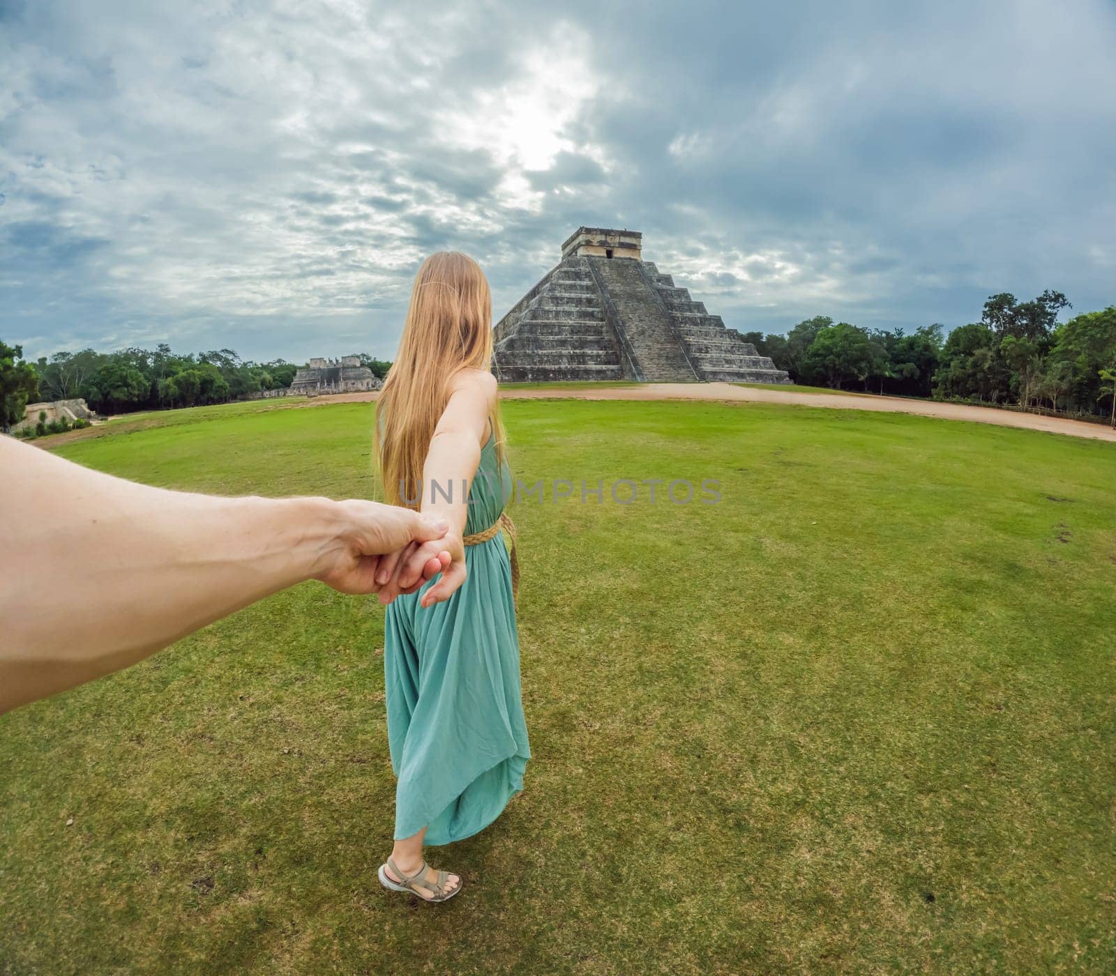 Beautiful tourist woman observing the old pyramid and temple of the castle of the Mayan architecture known as Chichen Itza these are the ruins of this ancient pre-columbian civilization and part of humanity by galitskaya