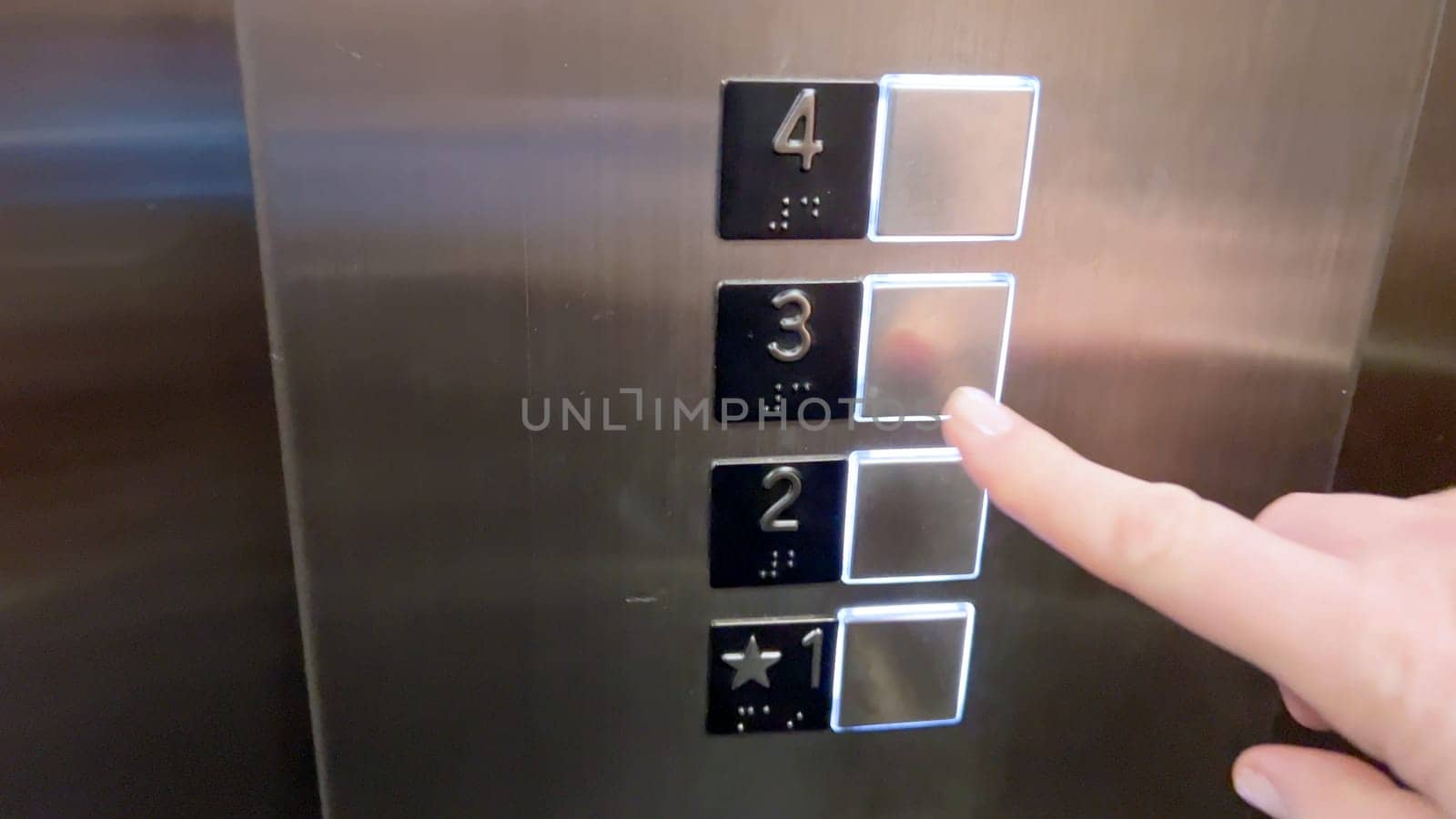 An elevator control panel displaying a set of floor buttons, with the second and third floors highlighted, indicating the current selections made by the users.