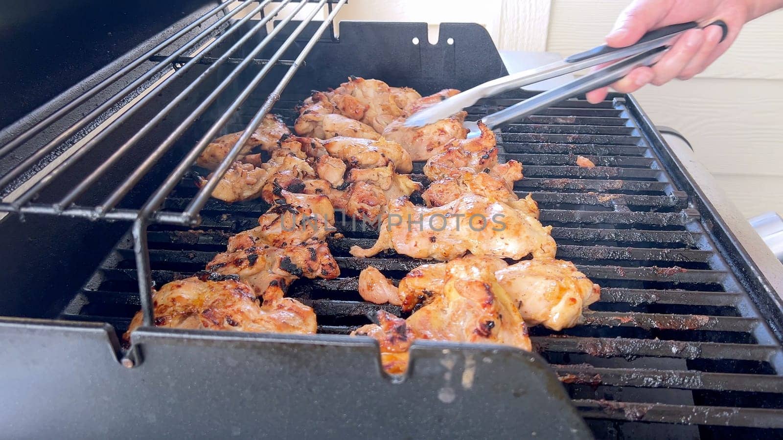 Grilling Marinated Chicken on an Outdoor BBQ Grill by arinahabich