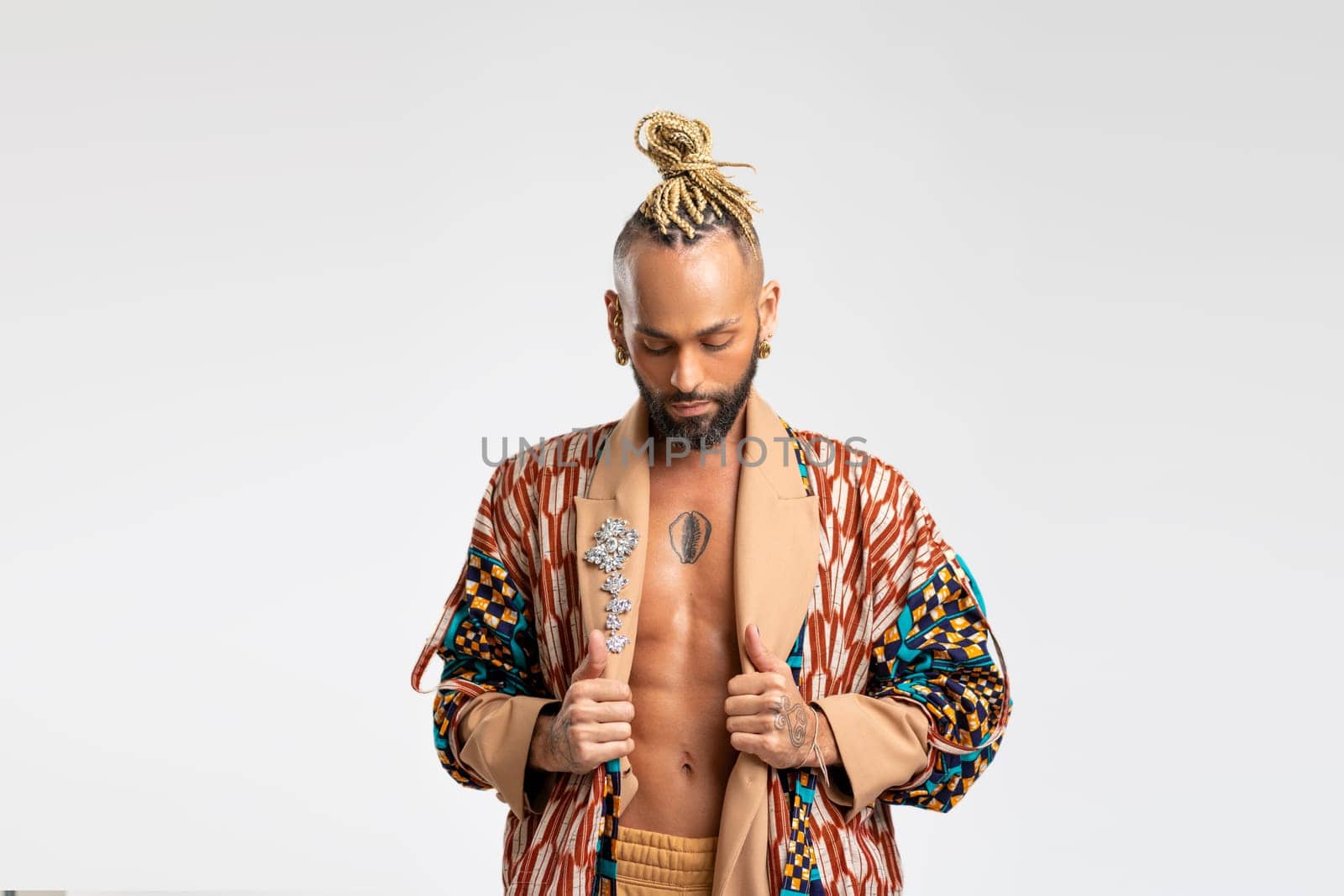 African-american guy wearing vibrant stylish jacket posing isolated on white background. Looking down with serious face young millennial man with perfect abdominal muscle