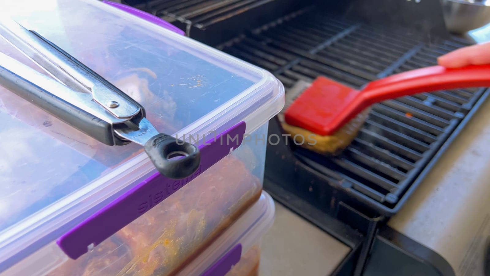 Cleaning a Barbecue Grill with a Brush After Cooking by arinahabich