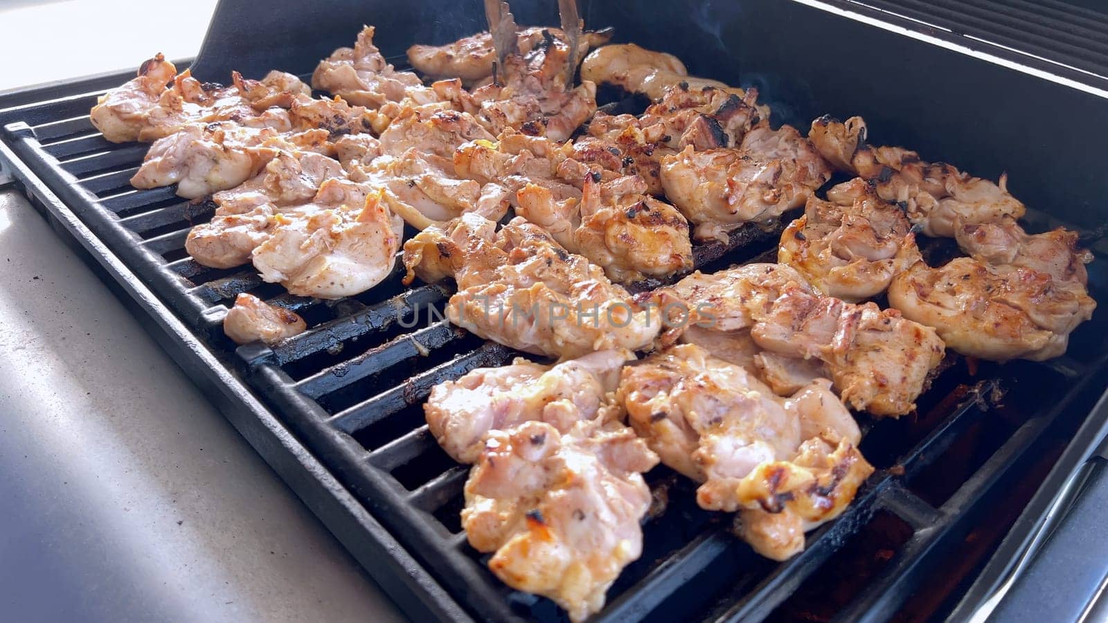 Grilling Marinated Chicken on an Outdoor BBQ Grill by arinahabich