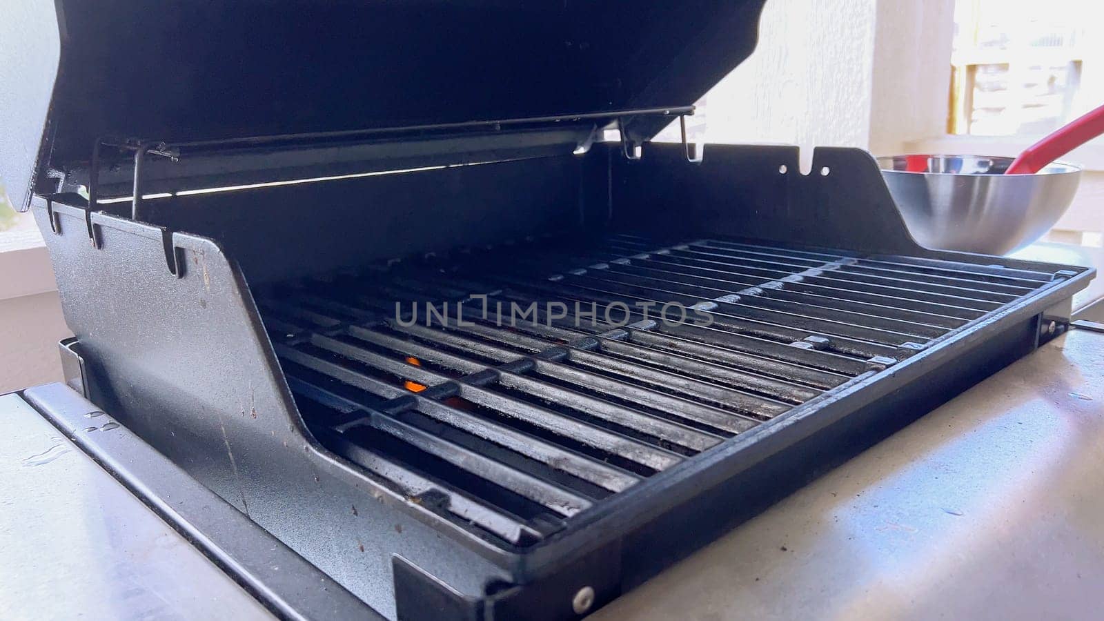 Cleaning a Barbecue Grill with a Brush After Cooking by arinahabich
