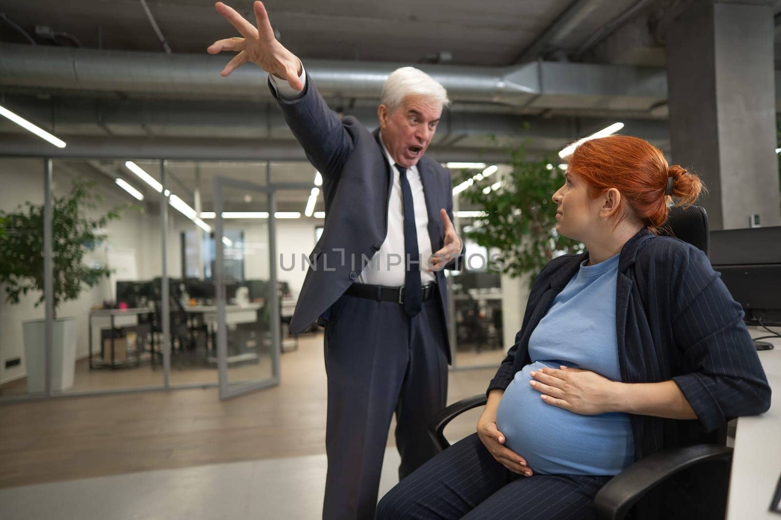 Elderly Caucasian man shouts at pregnant submissive woman and points to the door