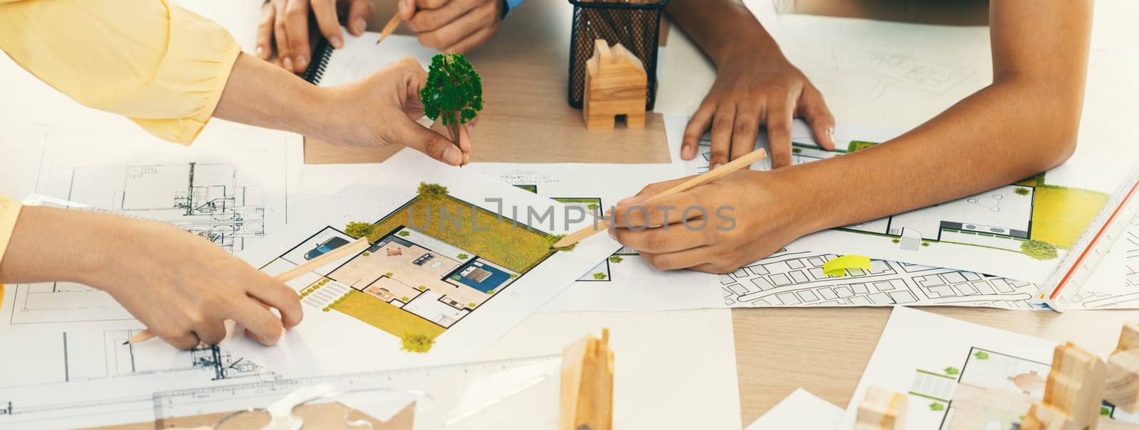 Professional architect engineer team discussion about architectural project on meeting table with wooden block and blueprint scatter around. Design and cooperate concept. Closeup. Delineation.