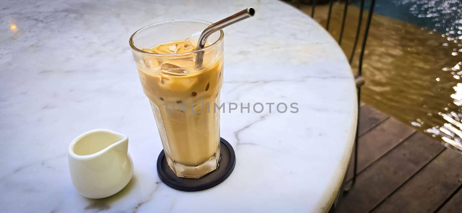 Fresh iced coffee in glass with frothy cream for your design, Food concept in style, copy space by antoksena