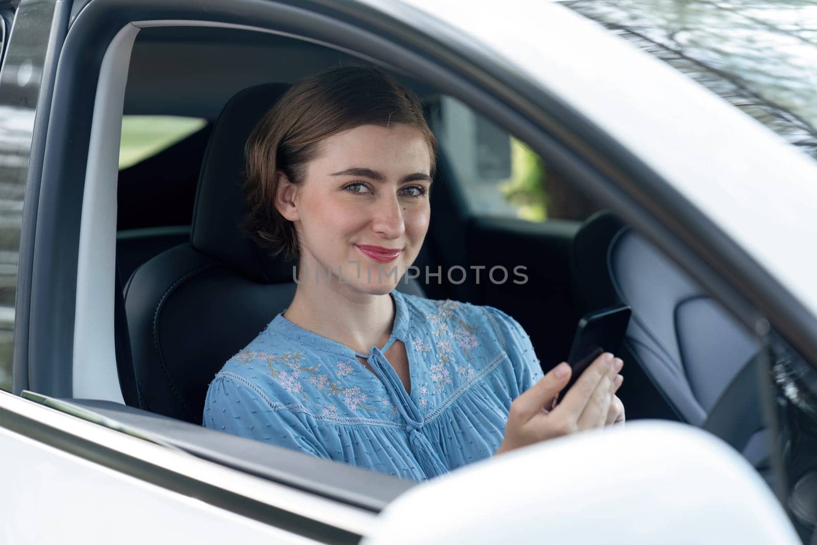 Beautiful woman in casual wear sitting on driver seat portrait. Cute girl driving a car concept with happy expression and pleasant smiling. Young woman with car road trip lifestyle. Perpetual