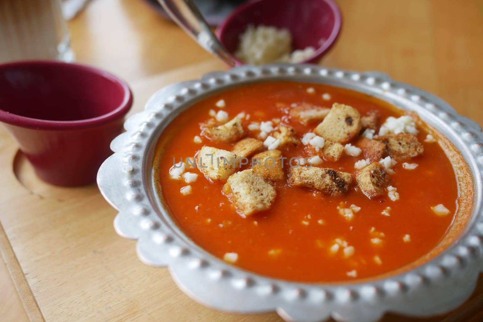 fresh tomato soup in a bowl on table by towfiq007