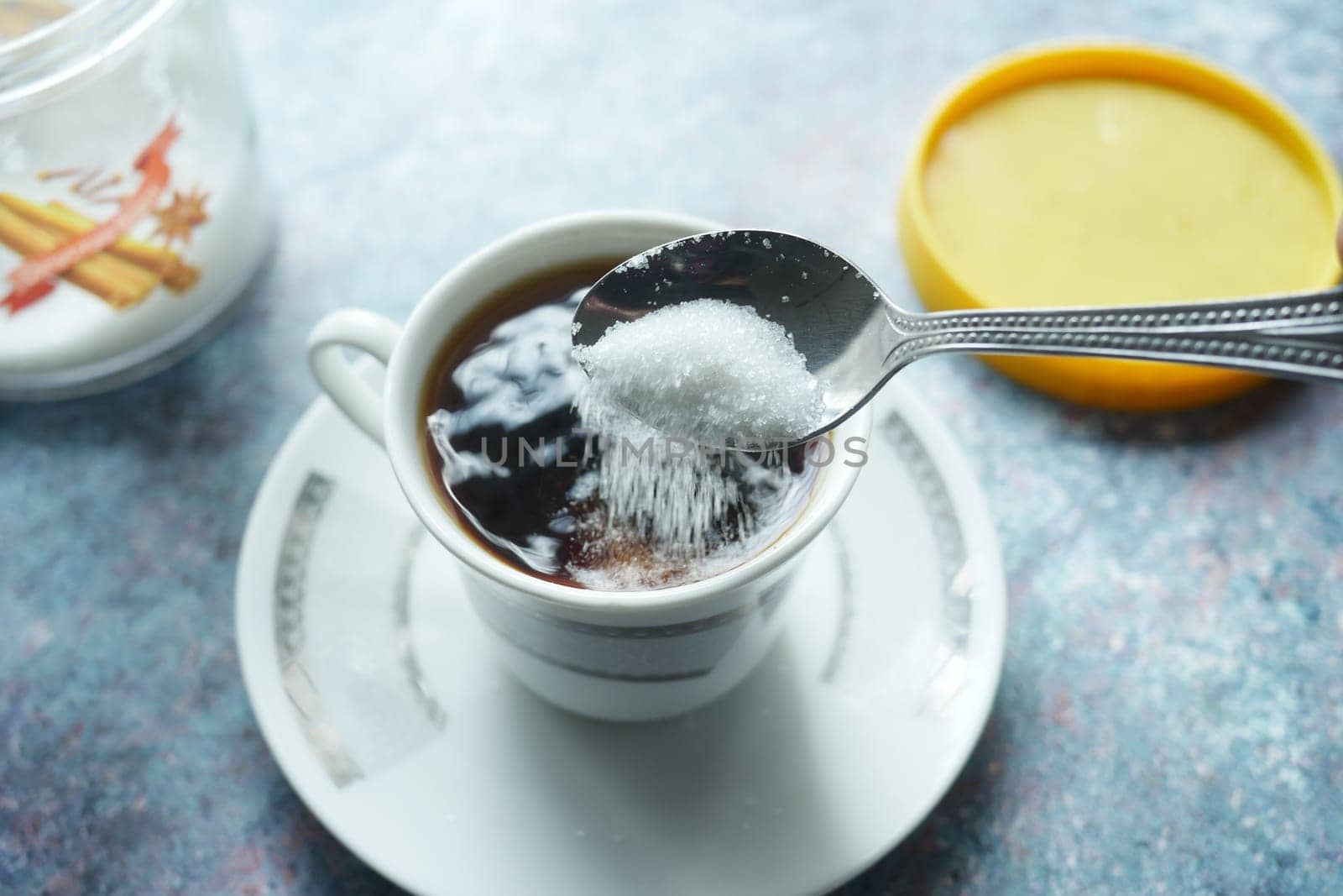 slow motion of pouring white sugar in a coffee cup , top view ,