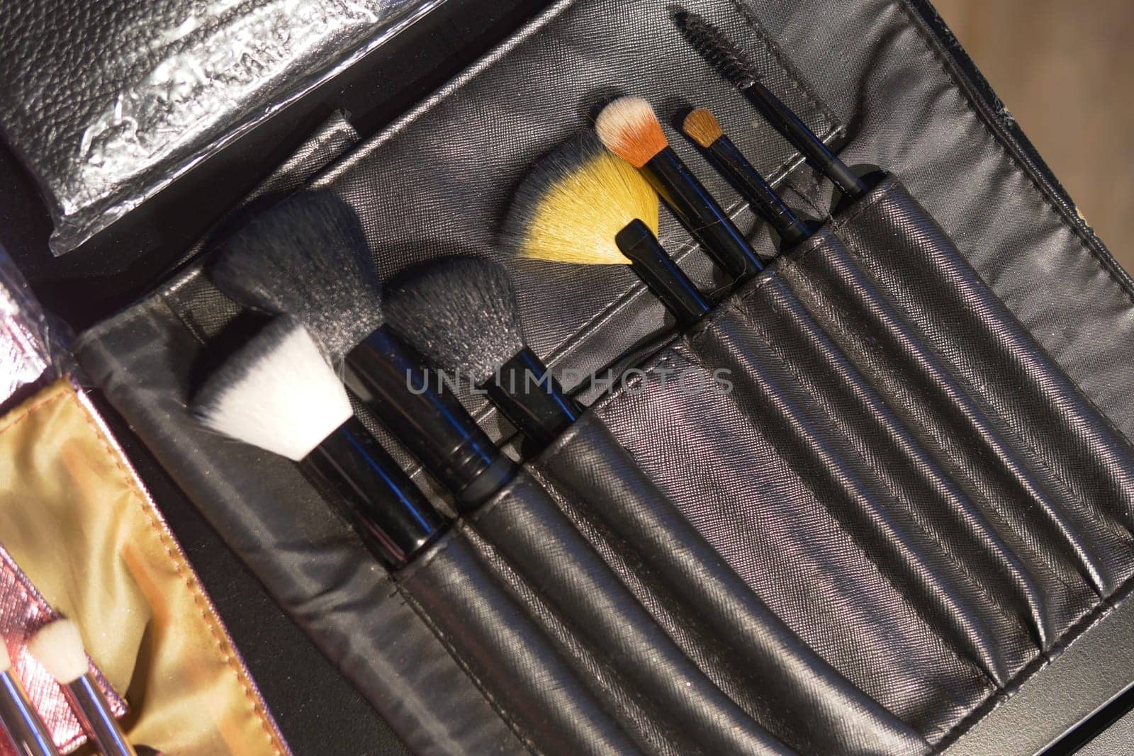 A set of makeup tools made of wood and metal, stored in a sleek black case. Perfect for those who love to experiment with different looks