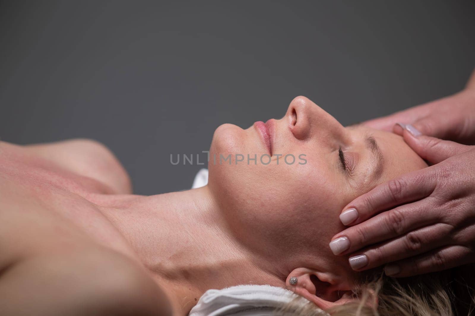 Caucasian woman undergoing head and face massage procedure