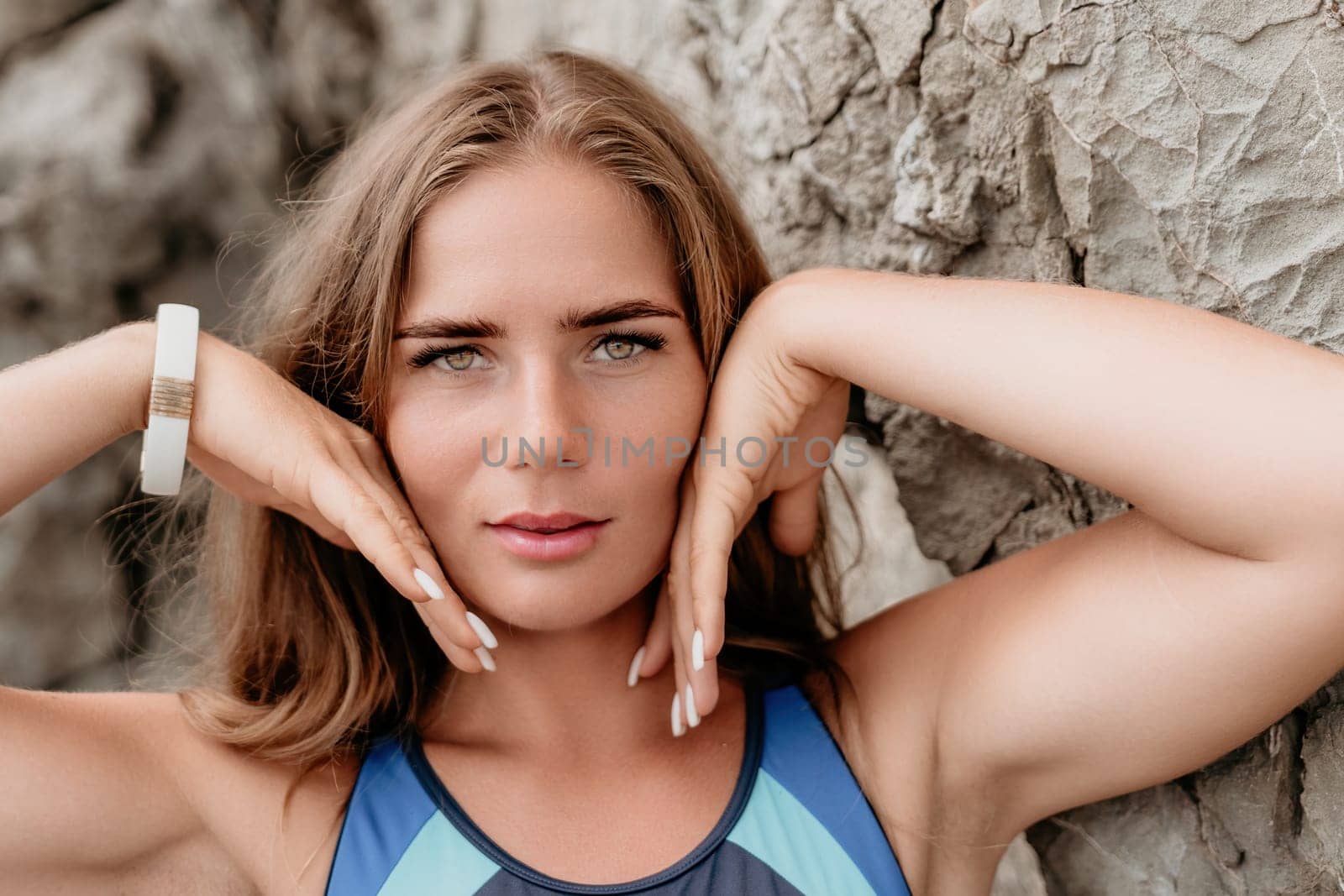 Woman summer travel sea. Happy tourist in blue bikini enjoy taking picture outdoors for memories. Woman traveler posing on the beach surrounded by volcanic mountains, sharing travel adventure journey by panophotograph