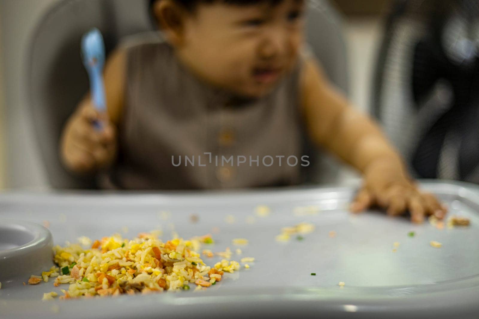 Little boy eating his food and making a mess.