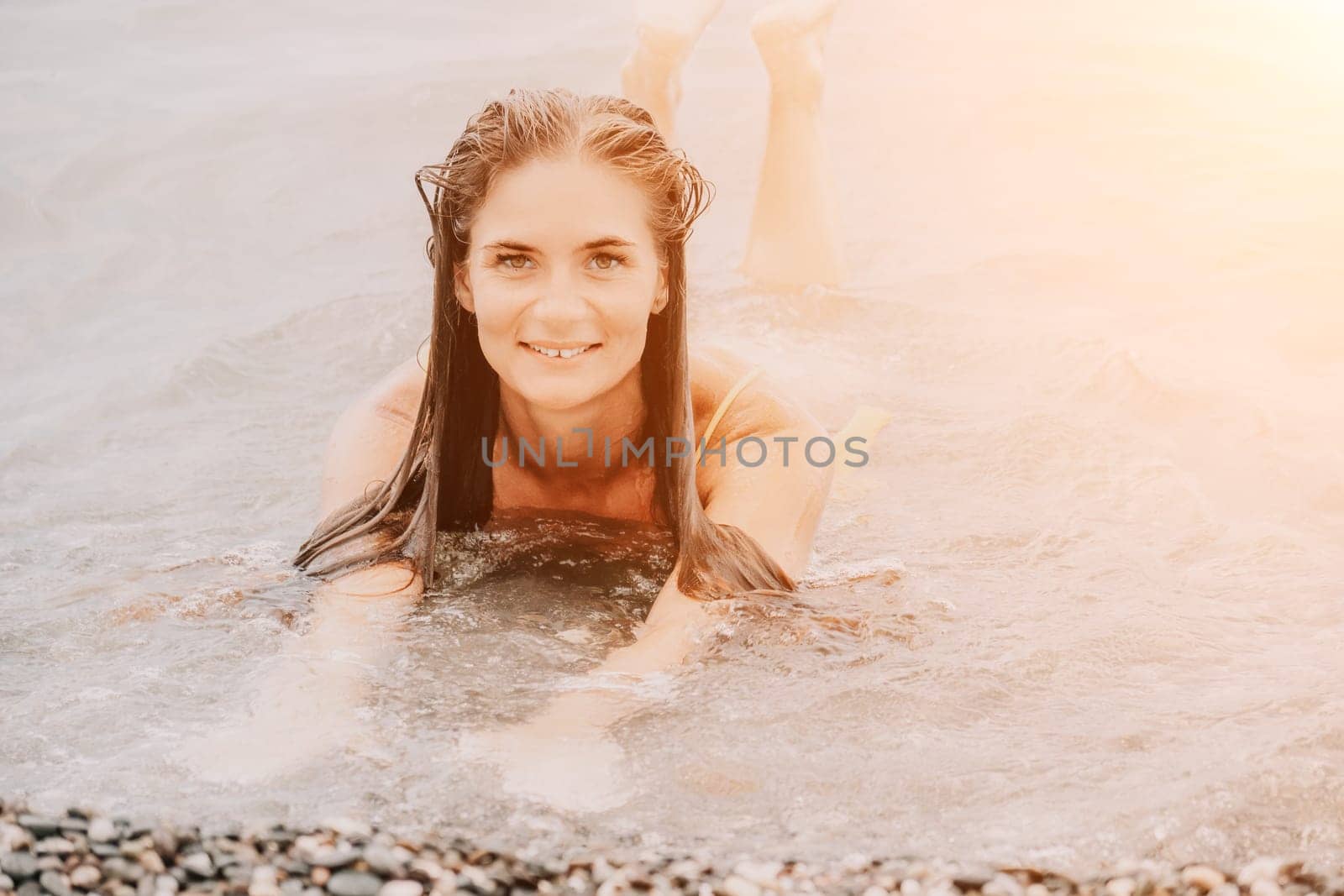 Woman travel sea. Young Happy woman in a long red dress posing on a beach near the sea on background of volcanic rocks, like in Iceland, sharing travel adventure journey