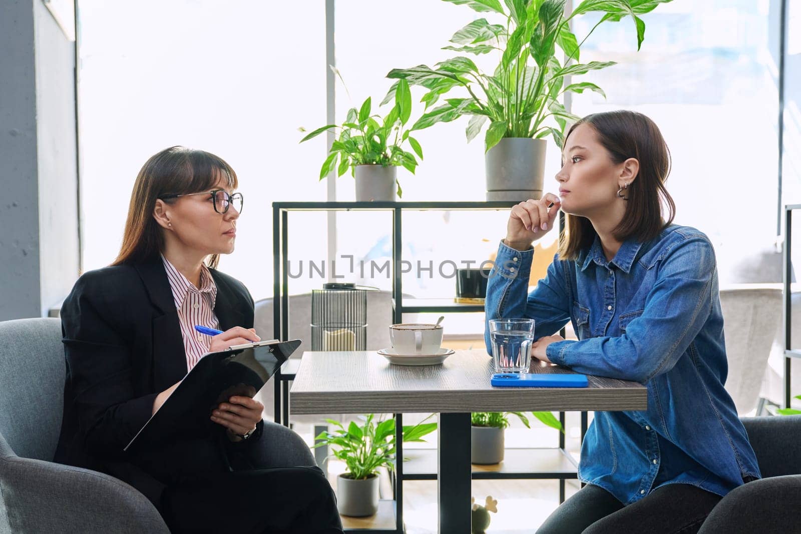 Young female patient at therapy meeting with professional psychologist, counselor, mental therapist. Psychology, psychotherapy, counseling, mental assistance, health support