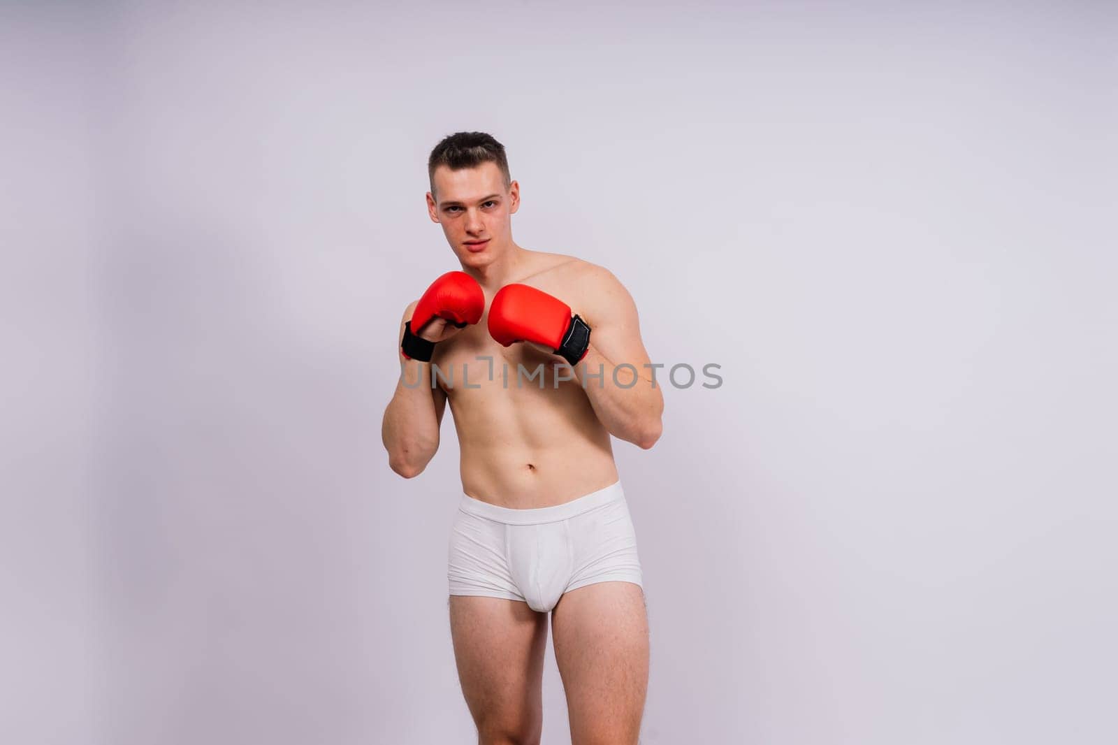 Studio shot of athlete boxer training. Concept of sport, healthy lifestyle. Red sportswear. by Zelenin