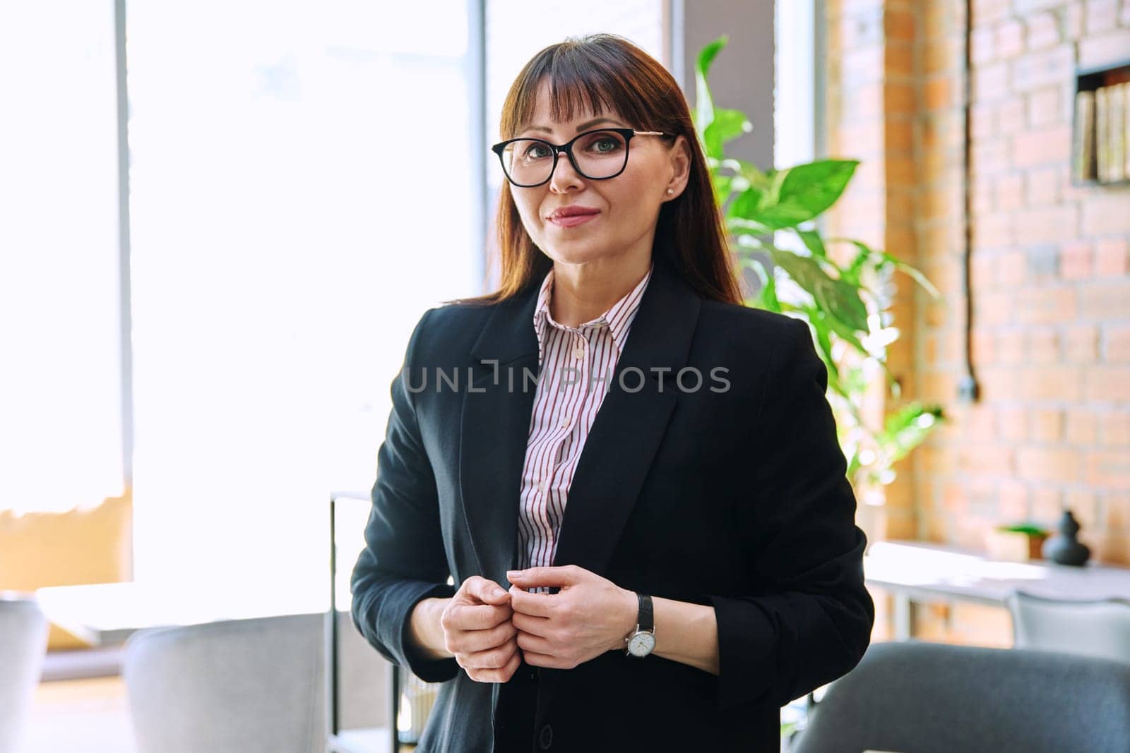 Portrait of confident mature business woman in suit looking at camera by VH-studio