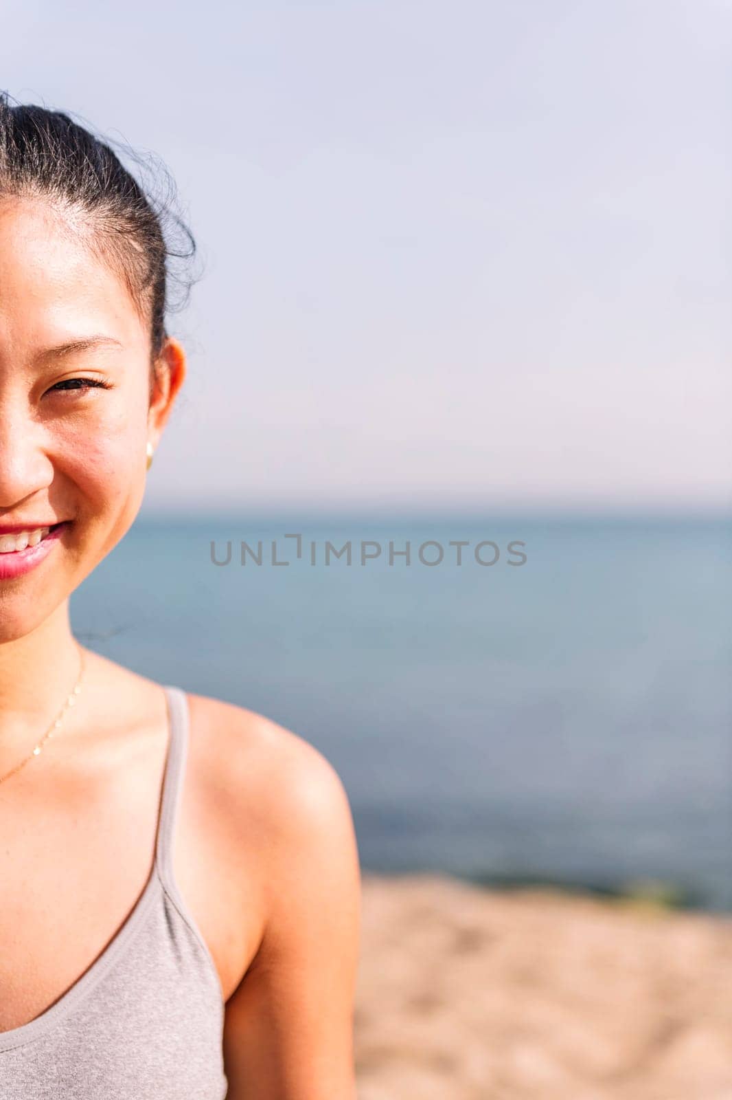 half portrait of a young asian woman smiling happy looking at camera, concept of beauty and purity, copy space for text