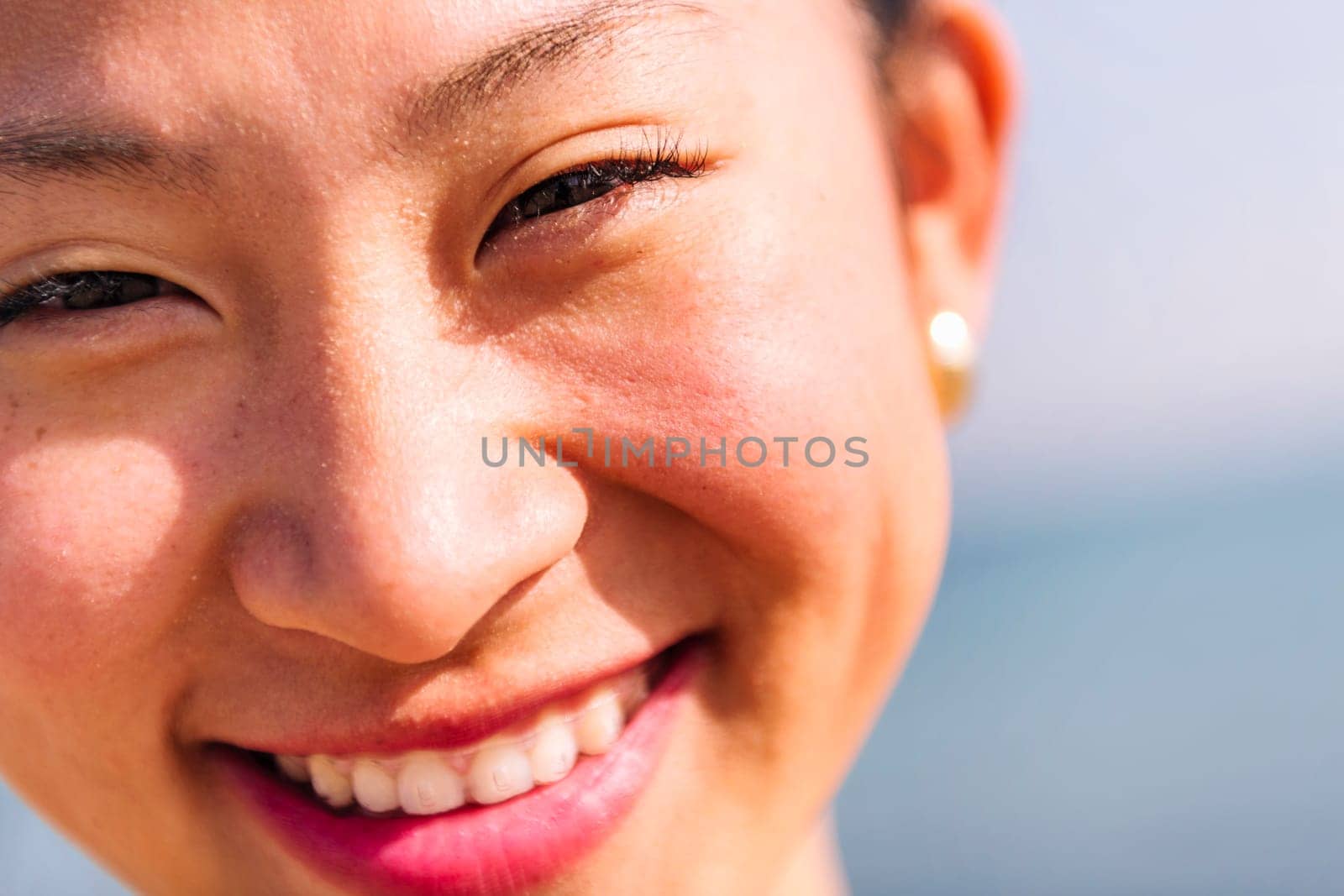 close up portrait of a cute asian woman with invisible braces smiling happy looking at camera, dental health and beauty concept