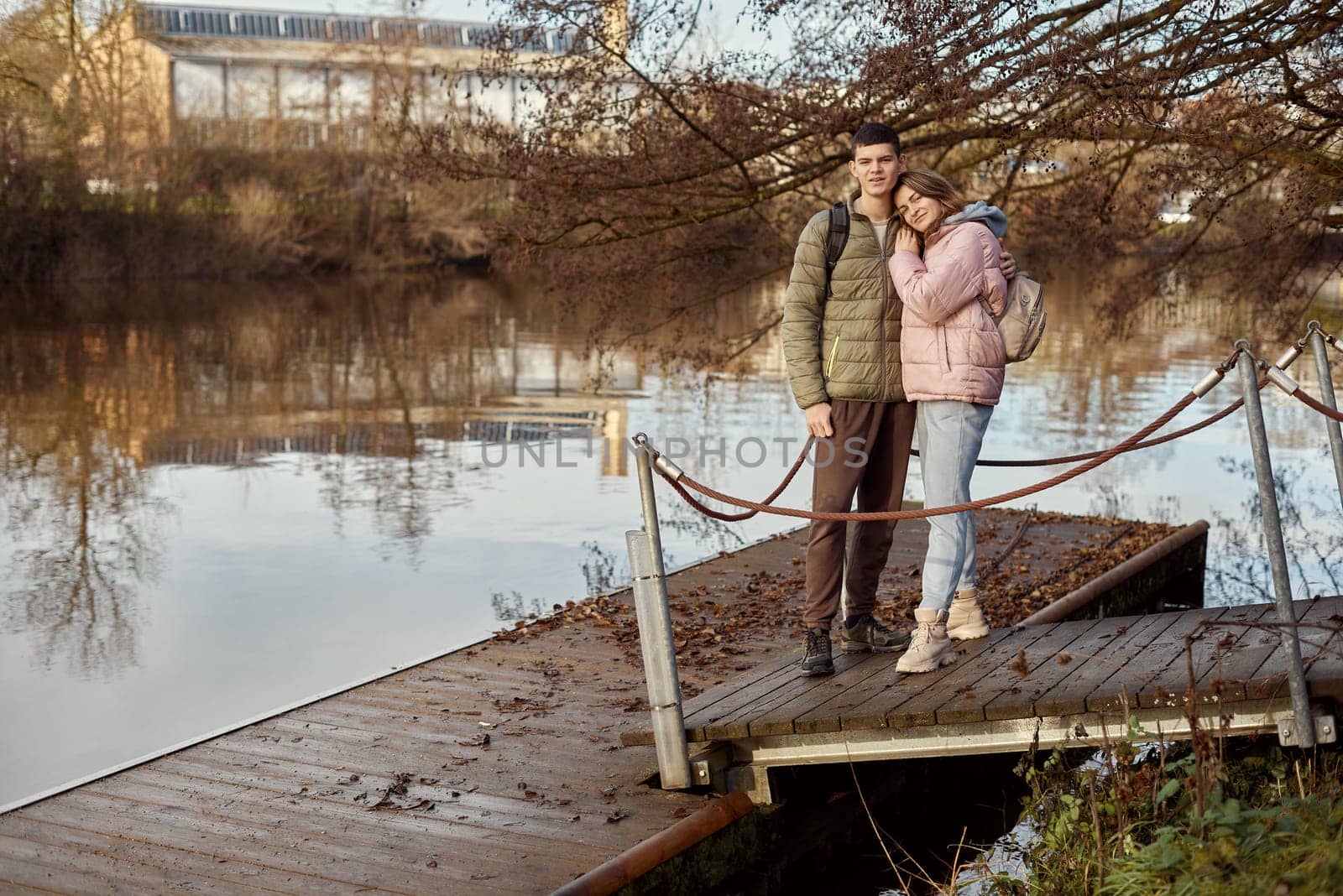 Embracing Moments: Beautiful 35-Year-Old Mother and 17-Year-Old Son in Winter or Autumn Park by Neckar River, Bietigheim-Bissingen, Germany by Andrii_Ko