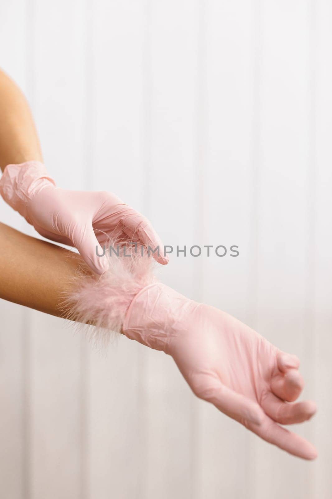 Woman Hands With Soft Feather. Body Care. Feather to female hand on white background. Concept of lightness easing and cleanliness. Hand Skin Care.