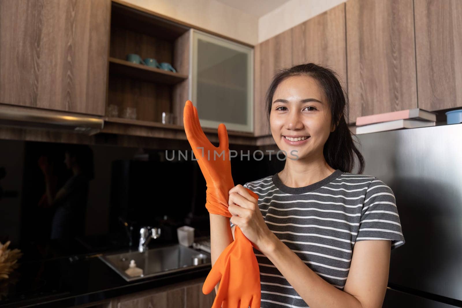 Female housekeeper smile and wearing glove, preparing to cleaning home by itchaznong