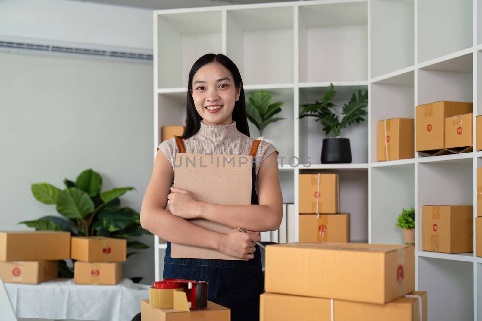 Woman asian in an online store check the customer address and package information on the laptop. Online shopping concept.
