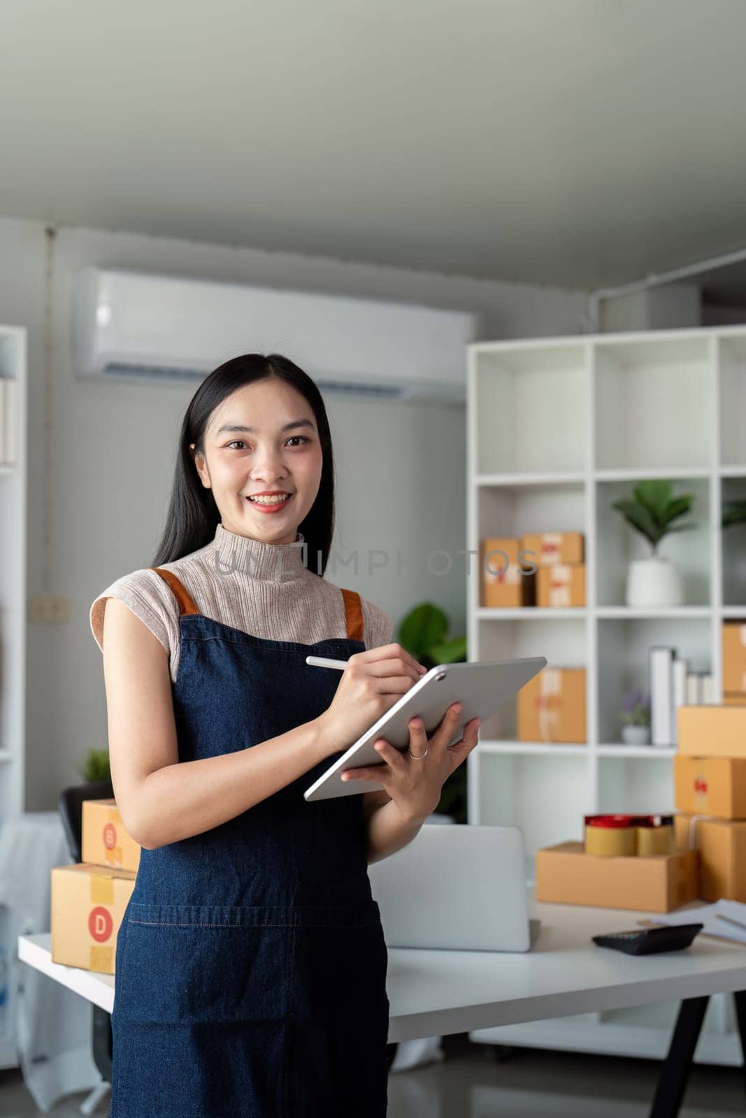 Young business woman asian working online ecommerce shopping at her shop. Young woman sell prepare parcel box of product for deliver to customer. Online selling by nateemee