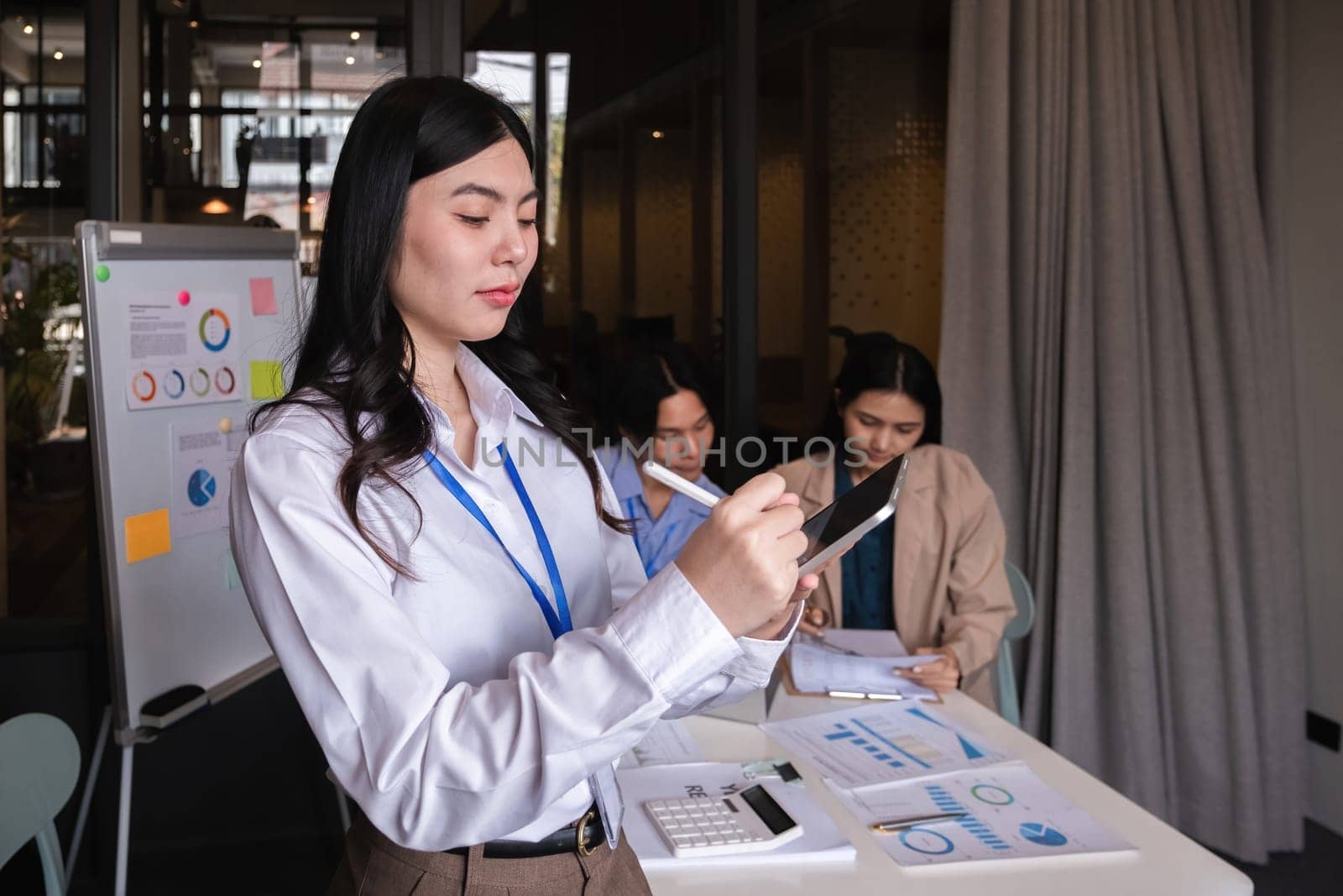 Portrait of a confident young businesswoman standing with a tablet at a conference room in her office..
