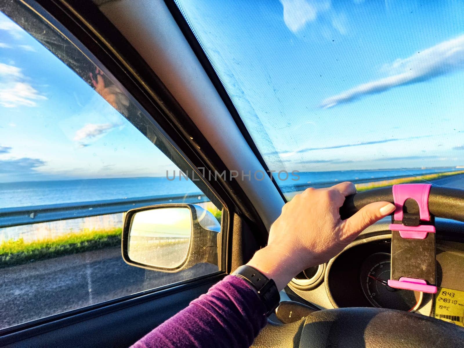 Car salon, windshield, hand of woman on steering wheel and landscape. View from seat of driver on nature. Single trip of female traveler by keleny