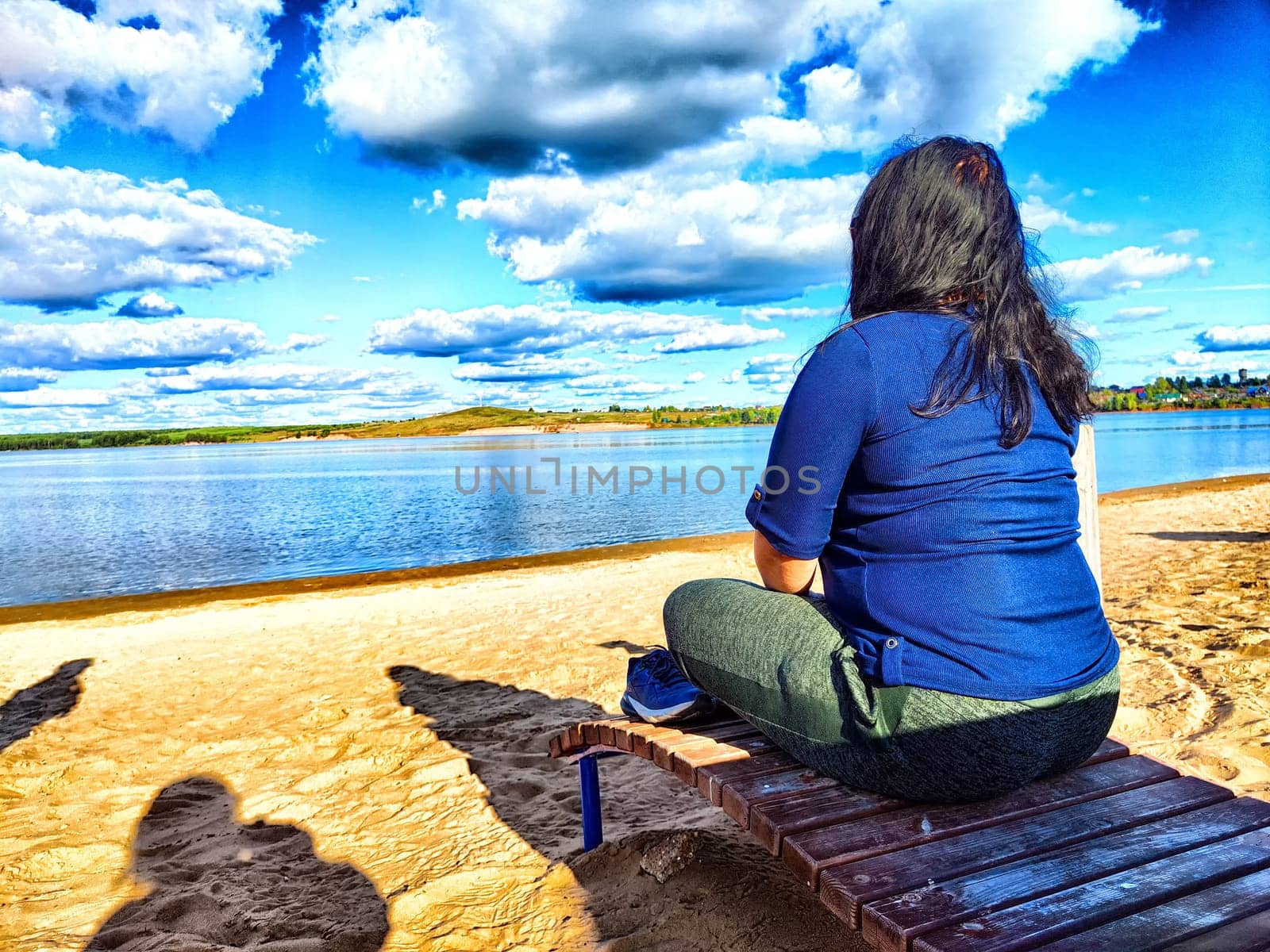 Serene Lakeside Contemplation at Sunset and plump woman. Female Person sitting on bench by a lake, reflecting under a vibrant sky