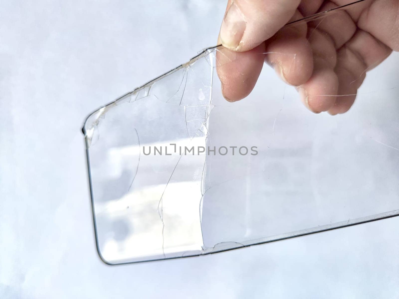 Removing Protective Film From Cracked Screen. Peeling off a cracked screen protector from a phone