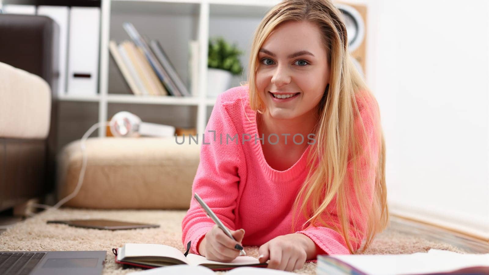 young beautiful blond woman lie on the floor read book by kuprevich