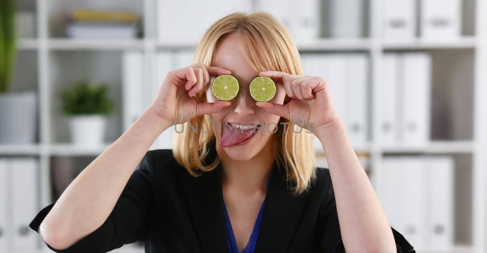 Female hands hold a cut fruit at eye level instead of glasses. The theme of a healthy diet for withdrawal activities and belief in diet achievements in business and education.