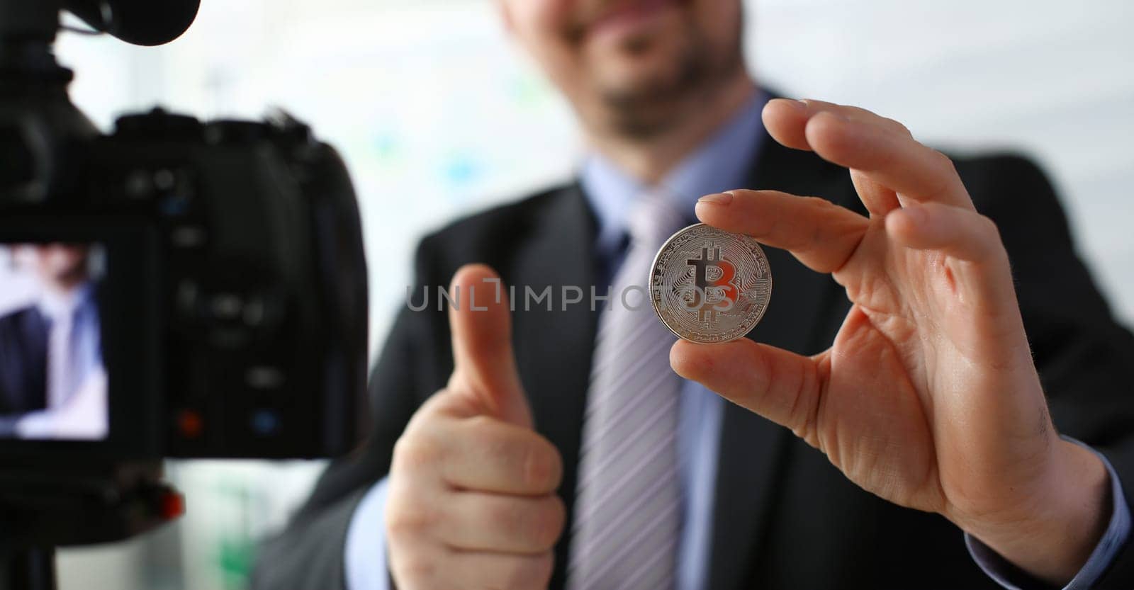 Business trainer hold silver bitcoin in hand by kuprevich