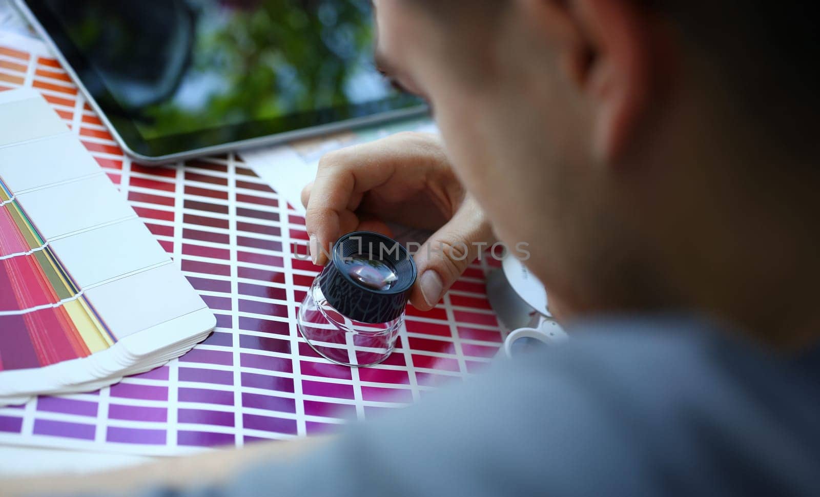 Male serviceman hold in hand magnifying glass making colour test by kuprevich