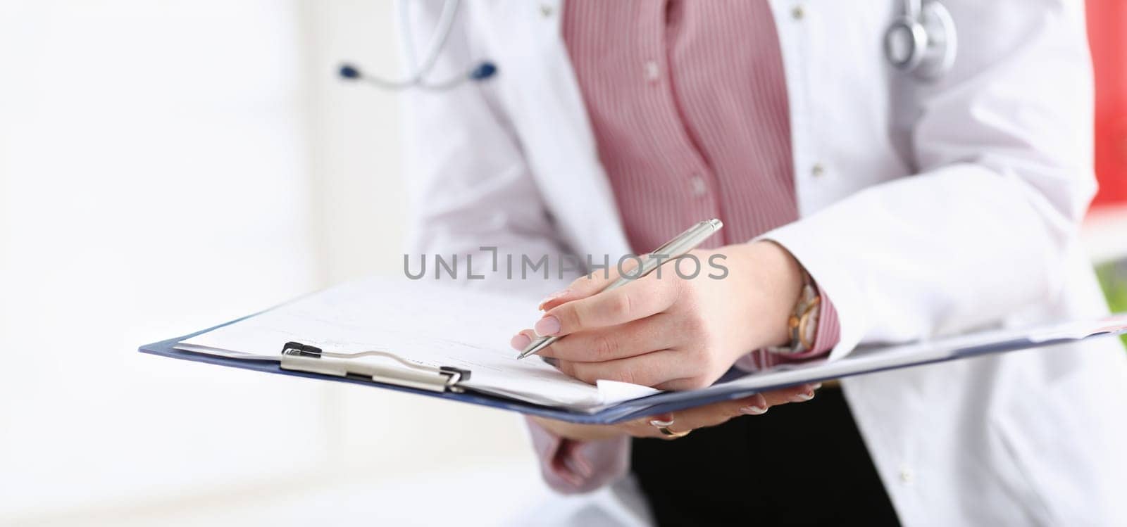 Male doctor arm hold silver pen filling patient complaints list clipped to pad. Physical exam er disease prevention ward round visitor check prescribe remedy healthy lifestyle concept