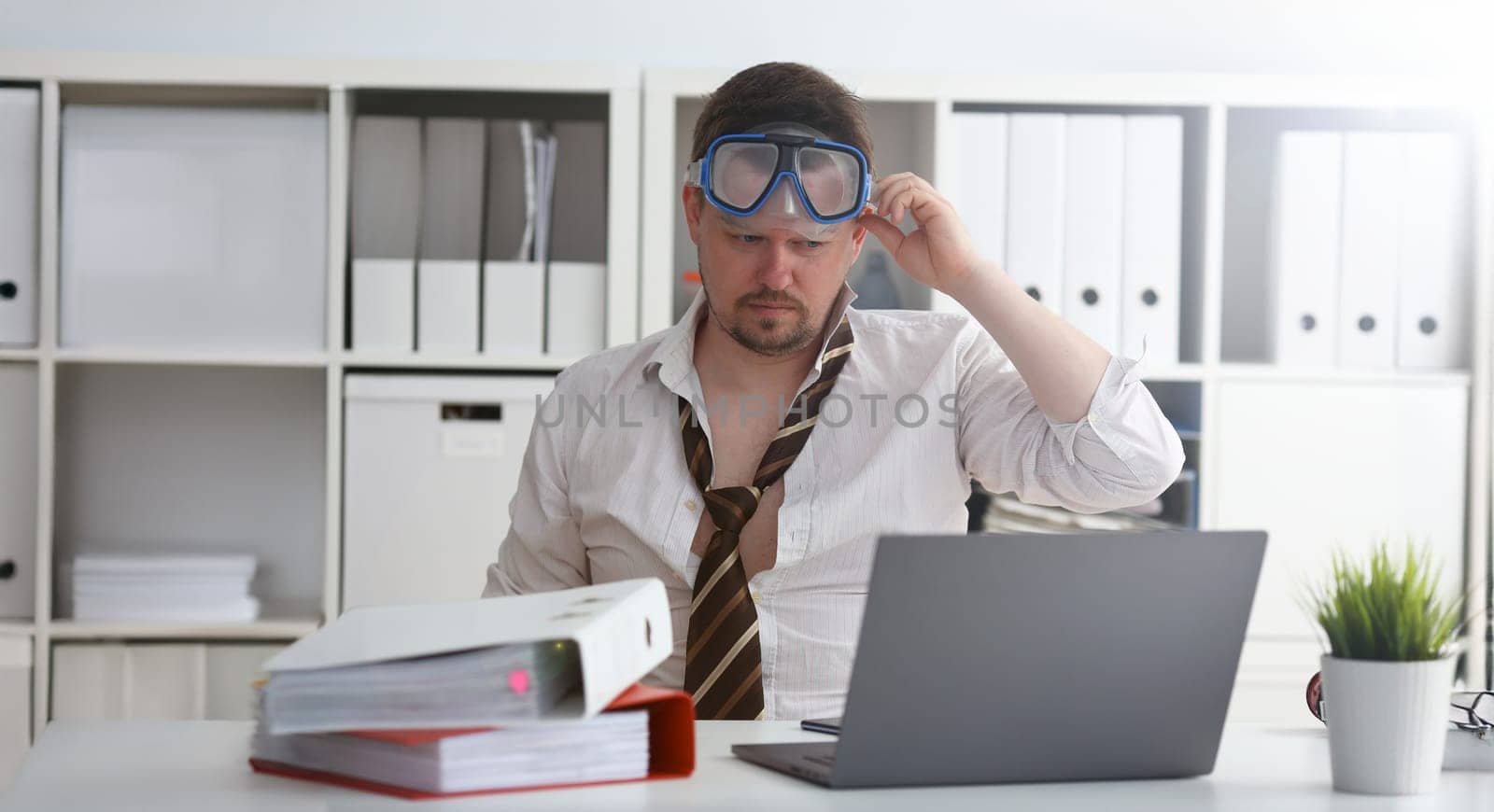 Man wearing suit and tie in goggles with snorkel sit at office workplace ready to take off portrait. Count days to leave annual day off workaholic freedom fun tourism resort idea concept