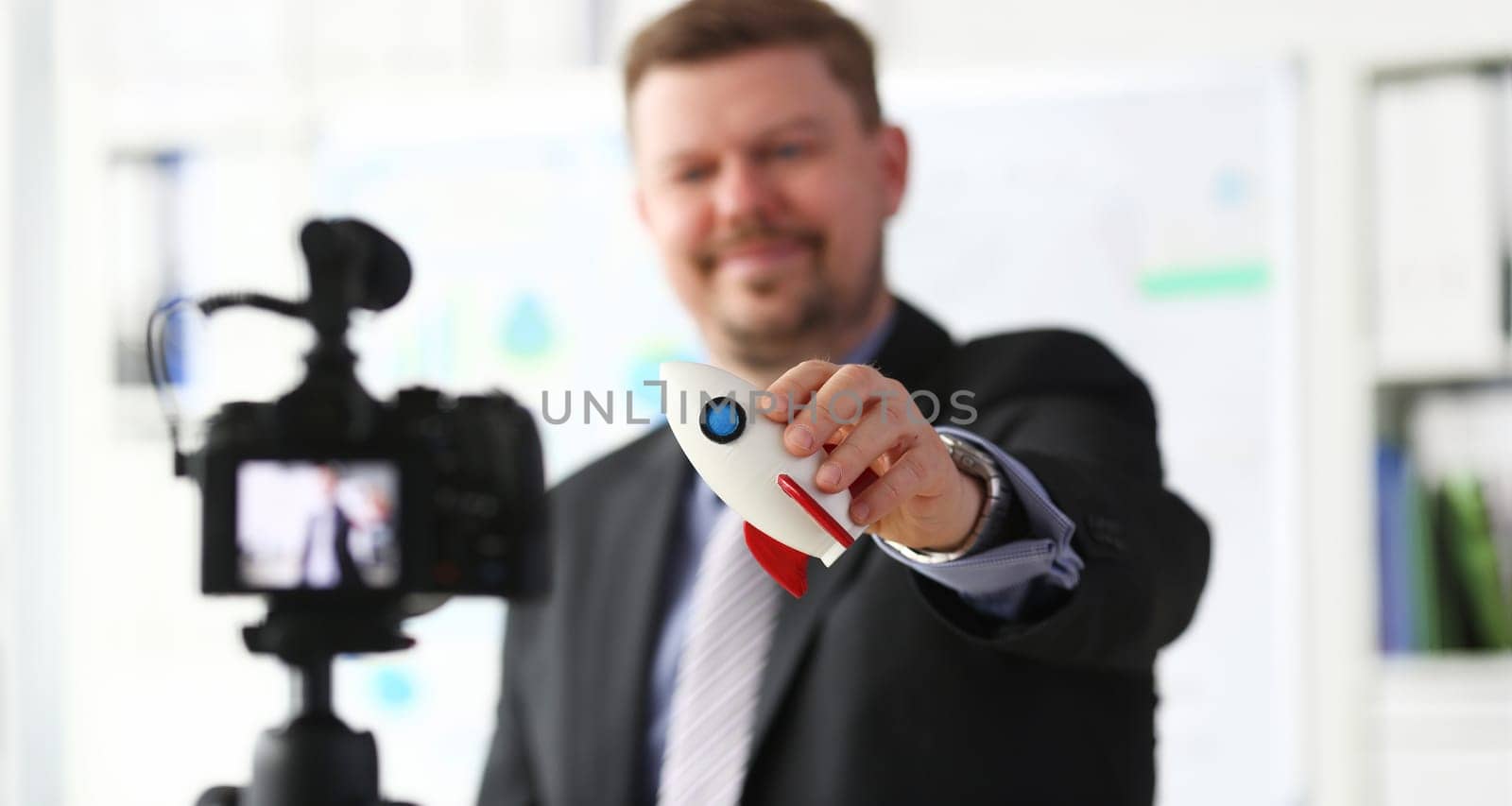 Businessman hold rocket in hand closeup on office background business concept