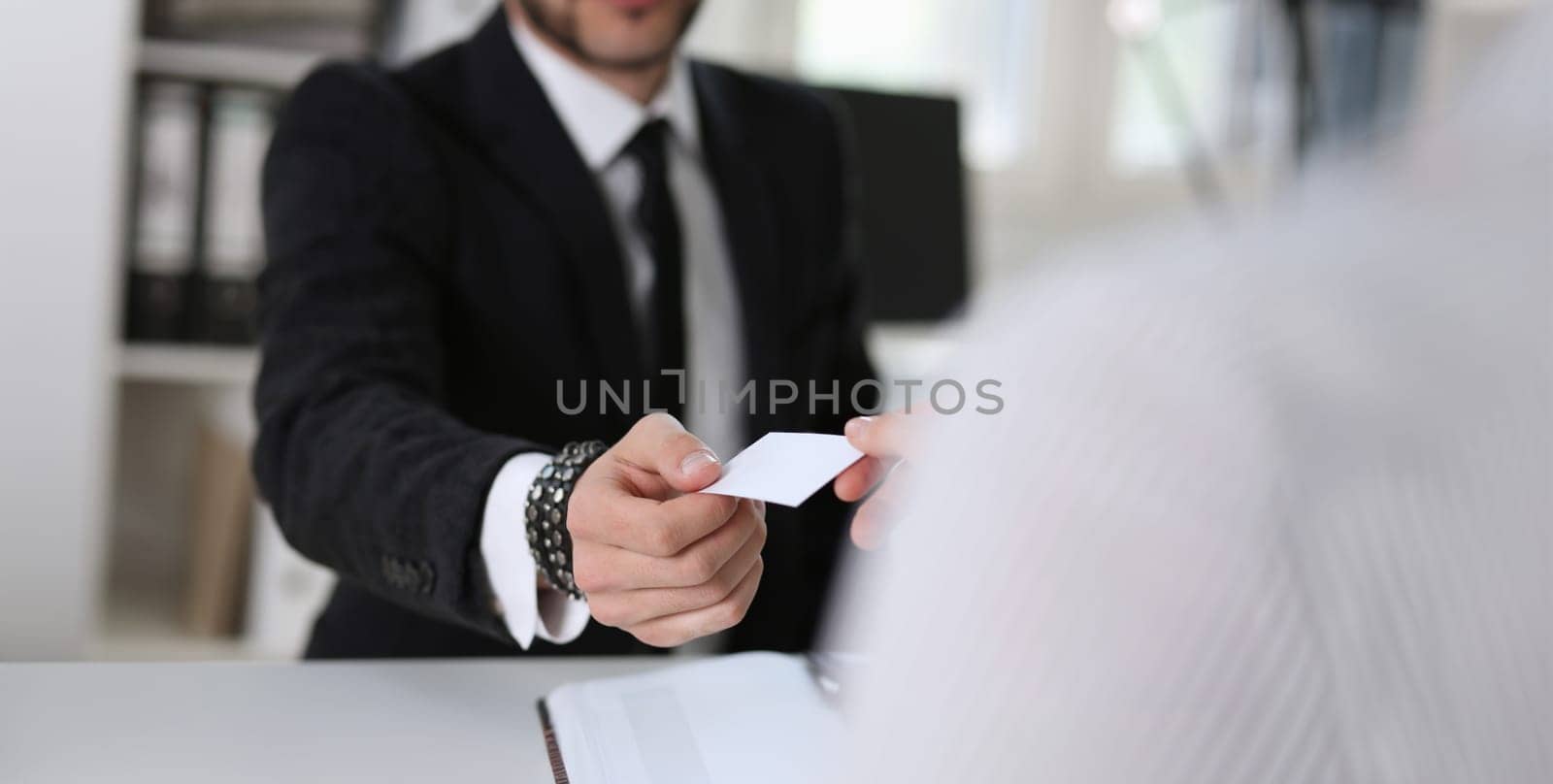 man give businesscard in office to his partner