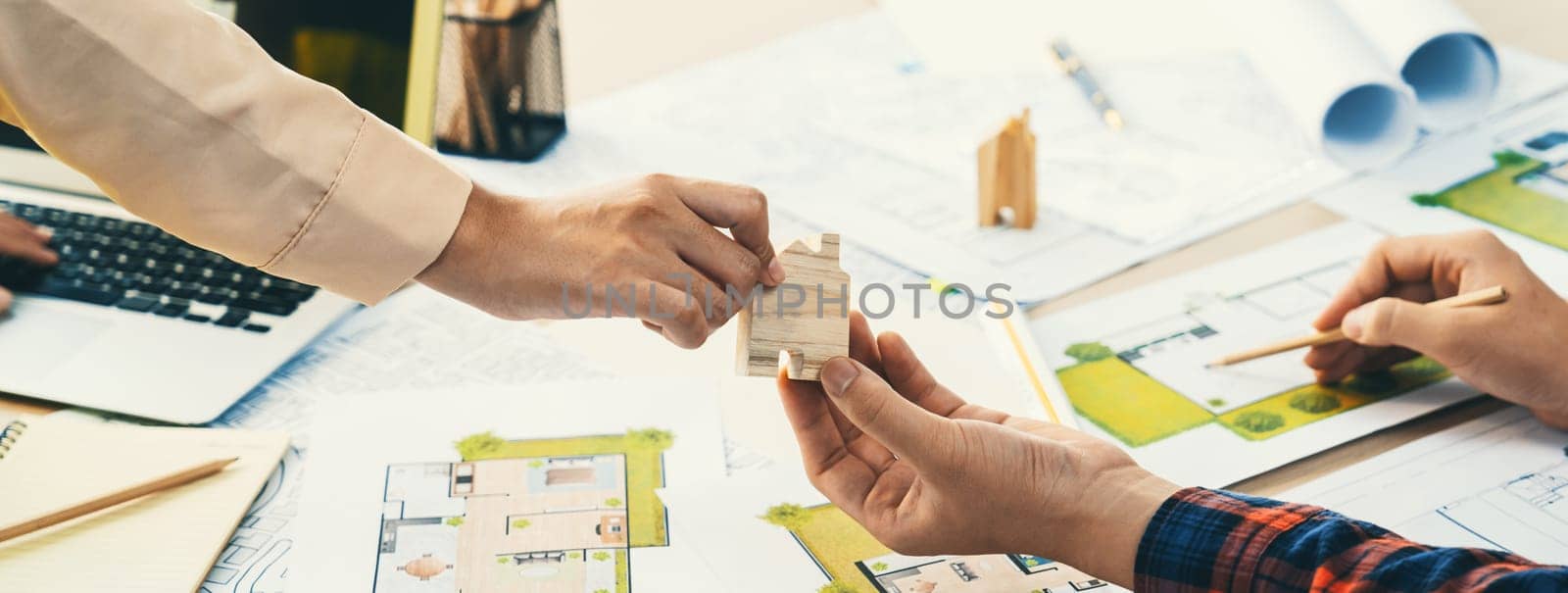 Professional engineer and architect collaborate on eco house project at meeting table with green design blueprint and architectural equipment at modern office. Focus on hand. Close up. Delineation.