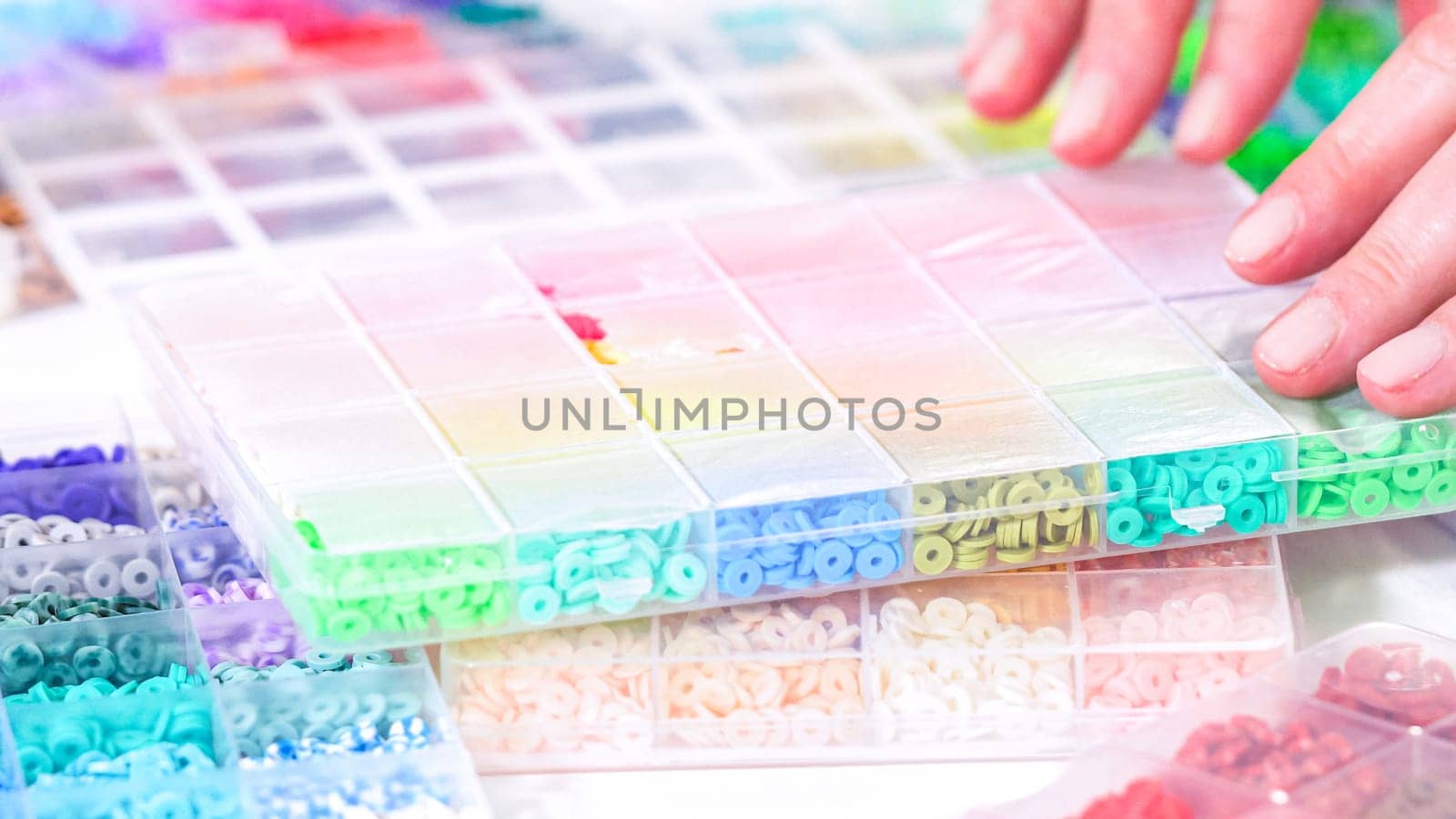 Woman Hands Amidst a Rainbow Array of Beads for Jewelry Crafting by arinahabich