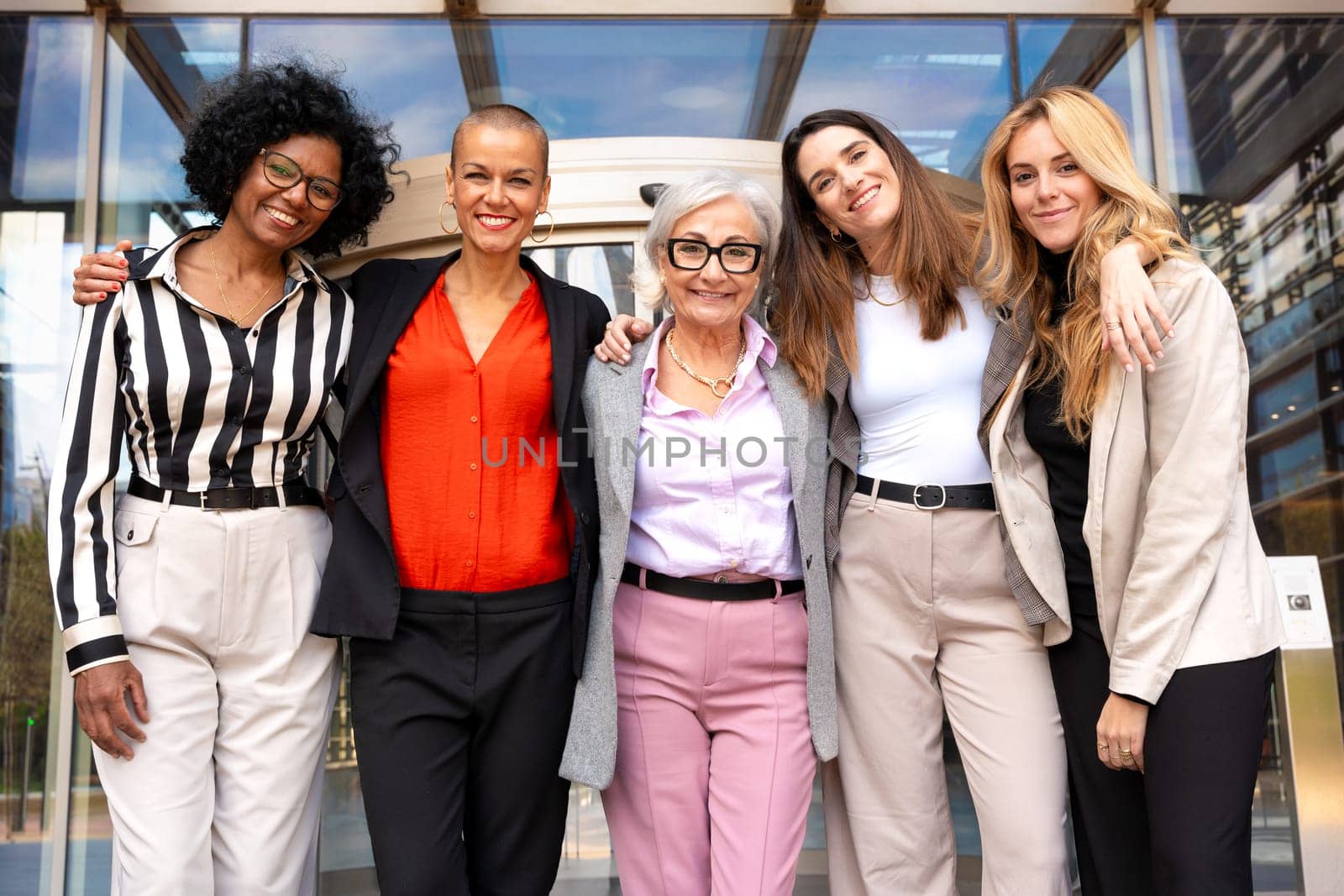 Five businesswomen standing, side by side looking at the camera, happy. Suitable for team, friendship and diversity concepts.