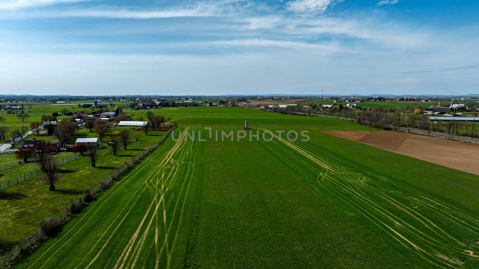 An Aerial View Of A Lush, Vibrant Farm Landscape With Distinct Green Fields.