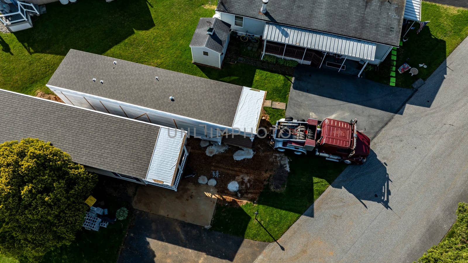 Aerial View of a Manufactured, Mobile, Prefab Double Wide Home Being Installed in a Lot in a Park by actionphoto50