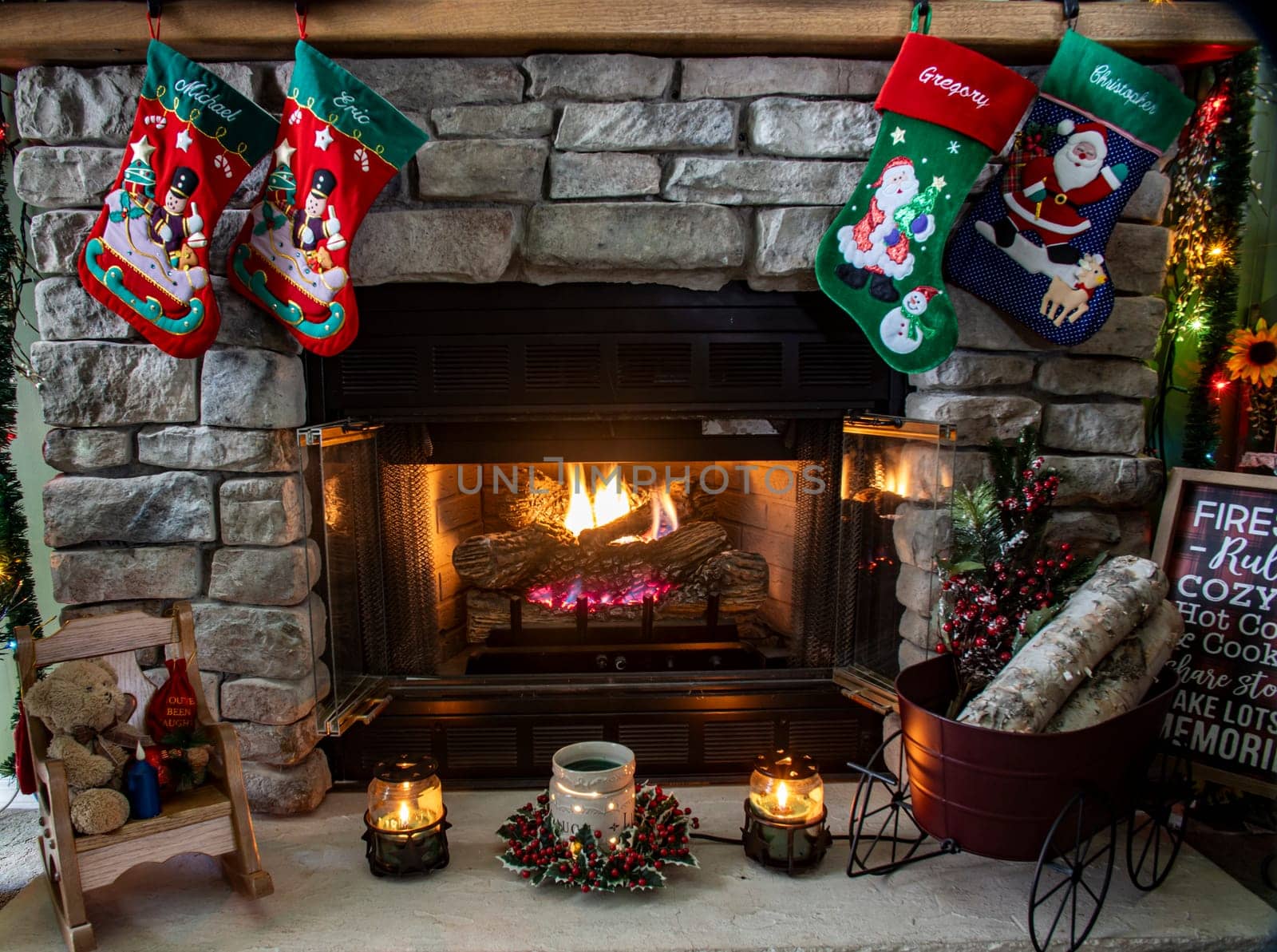 Fireplace with red green stocking hanging from it. Stocking is decorated with a santa and a snowman by actionphoto50