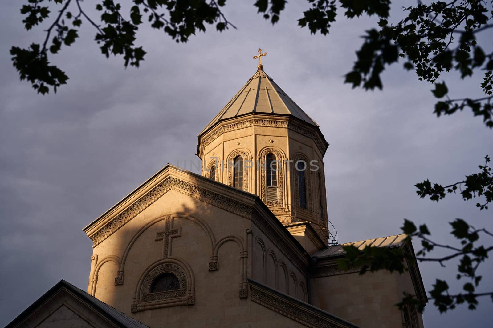 The Kashveti Church of St. George in central Tbilisi, located across from the Parliament building on Rustaveli Avenue. Dramatic light on dark clouds background. by berezko
