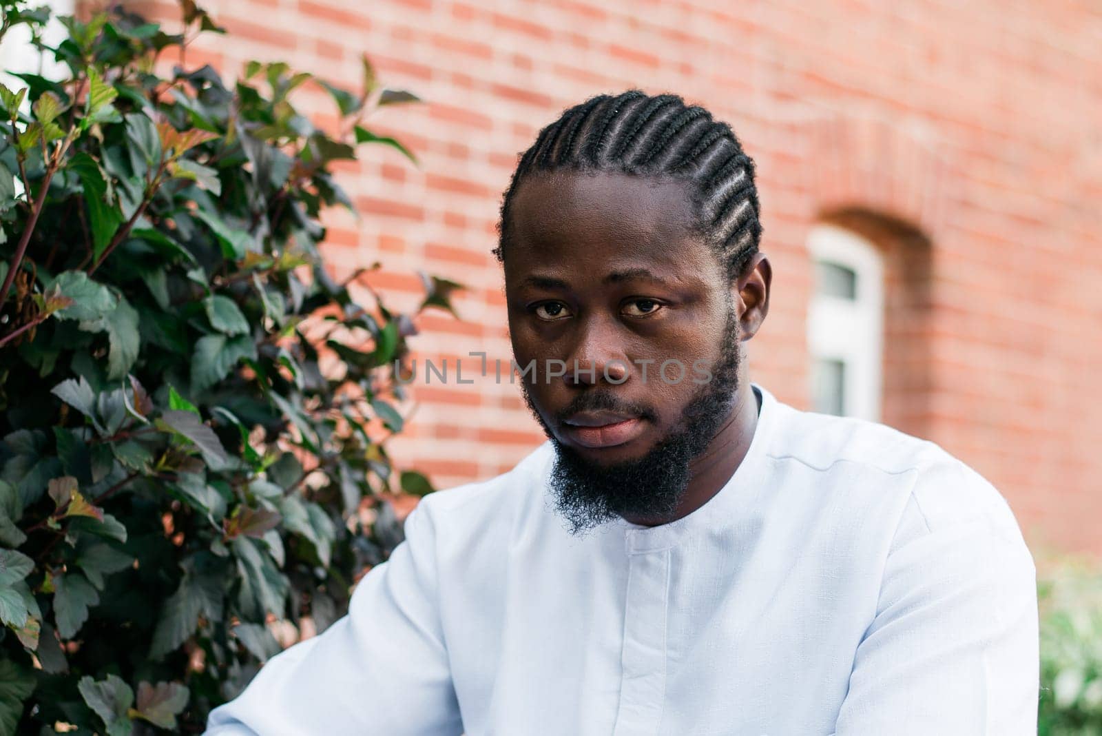 Banner portrait of a happy african american man smiling wearing ethnic dashiki clothes outdoor in summer street wall. Millennial generation student and youth. Copy space.